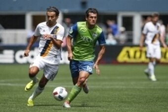Jul 9, 2016; Seattle, WA, USA; Seattle Sounders FC forward Nelson Valdez (16) dribbles against Los Angeles Galaxy midfielder Baggio Husidic (6) during the second half at CenturyLink Field. Los Angeles defeated Seattle, 1-0. Mandatory Credit: Joe Nicholson