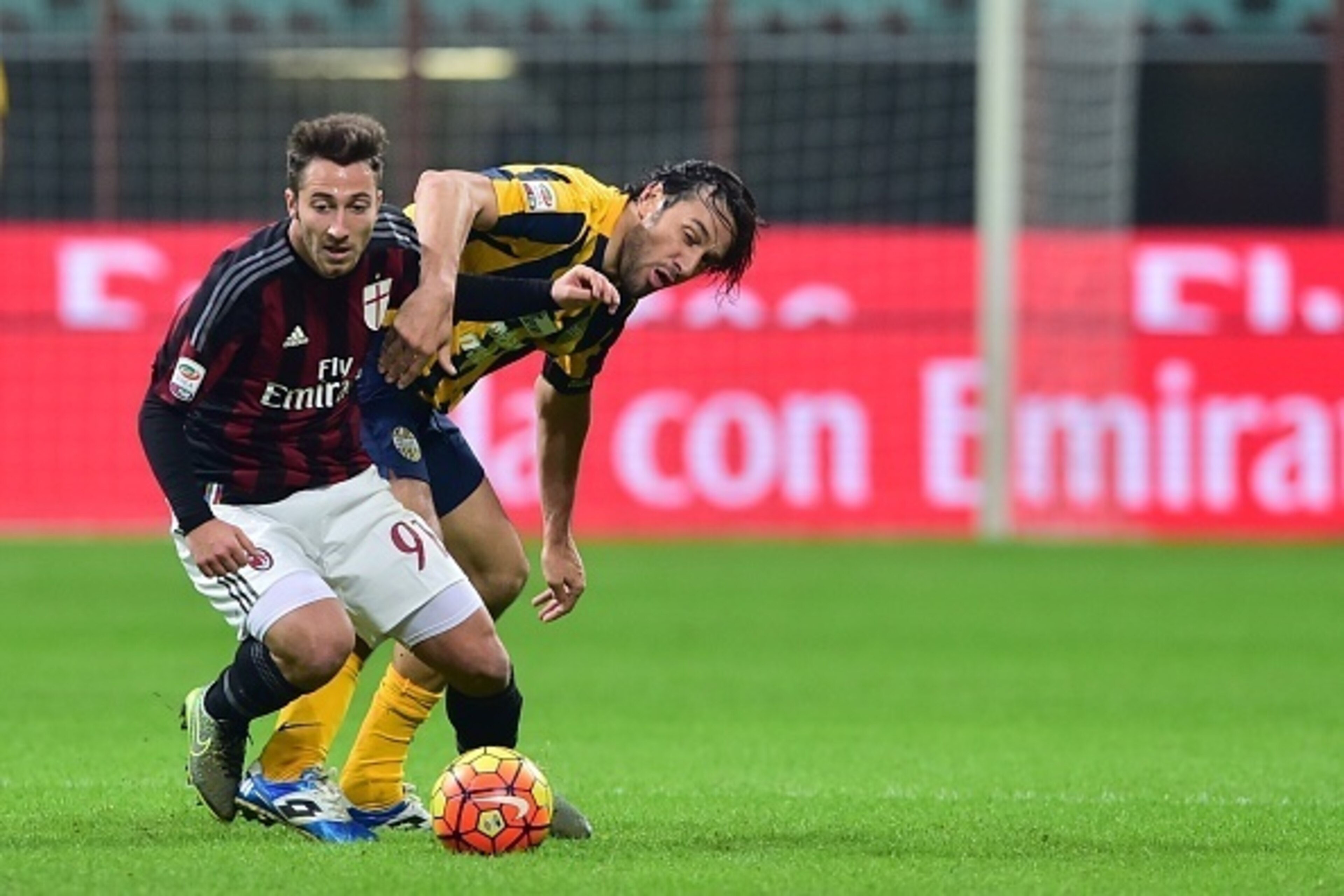AC Milan's midfielder from Italy Andrea Bertolacci (L) fights for the ball with Hellas Verona's forward from Italy Luca Toni during the Italian Seria A football match AC Milan vs Hellas Verona at San Siro Stadium in Milan on December 13, 2015. AFP PHOTO /