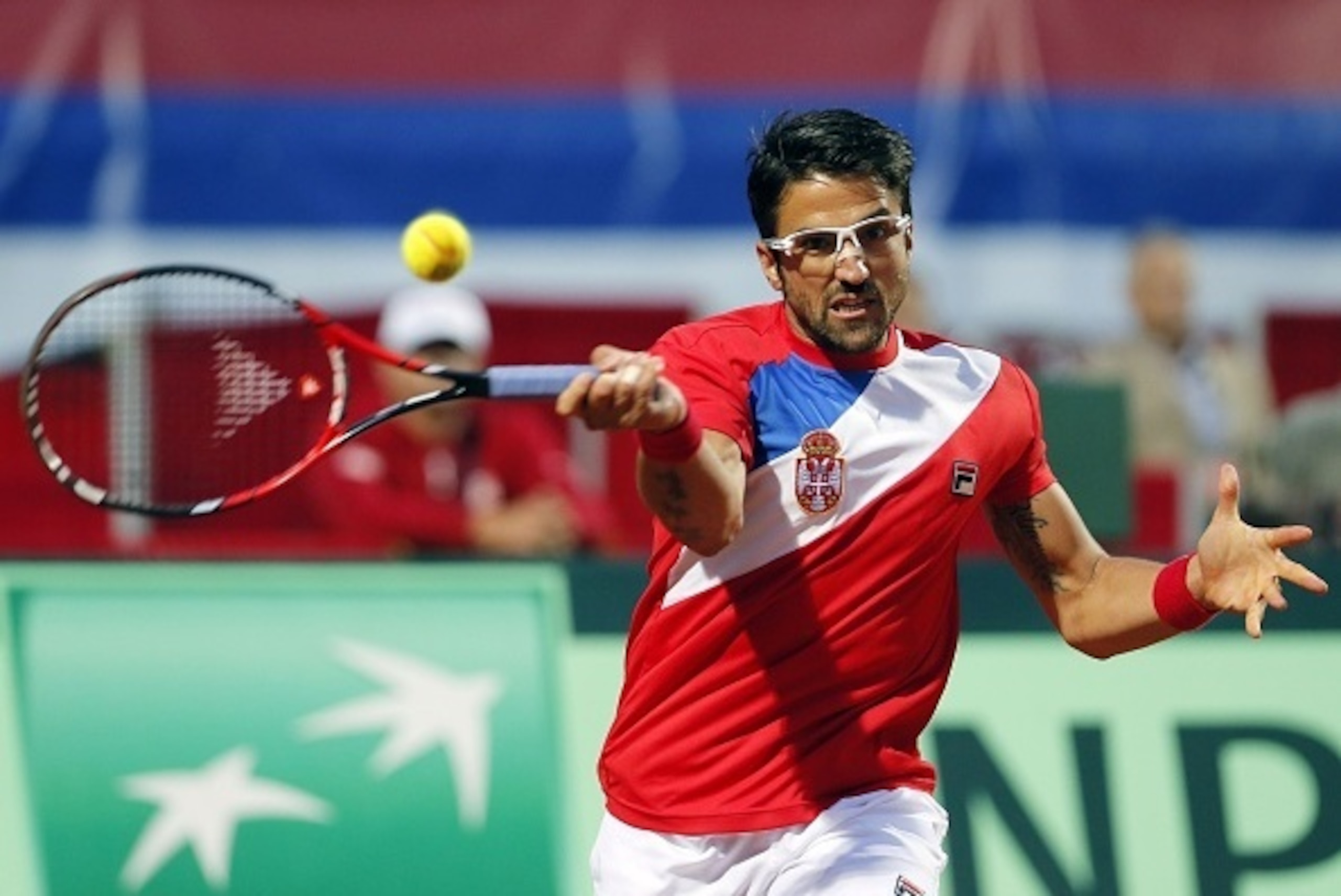Serbia's Janko Tipsarevic returns the ball to Britain's Kyle Edmund during the Davis Cup World Group quarter-final single men's tennis match between Serbia and Britain at the Tasmajdan stadium in Belgrade on July 15, 2016.  / AFP / PEDJA MILOSAVLJEVIC    