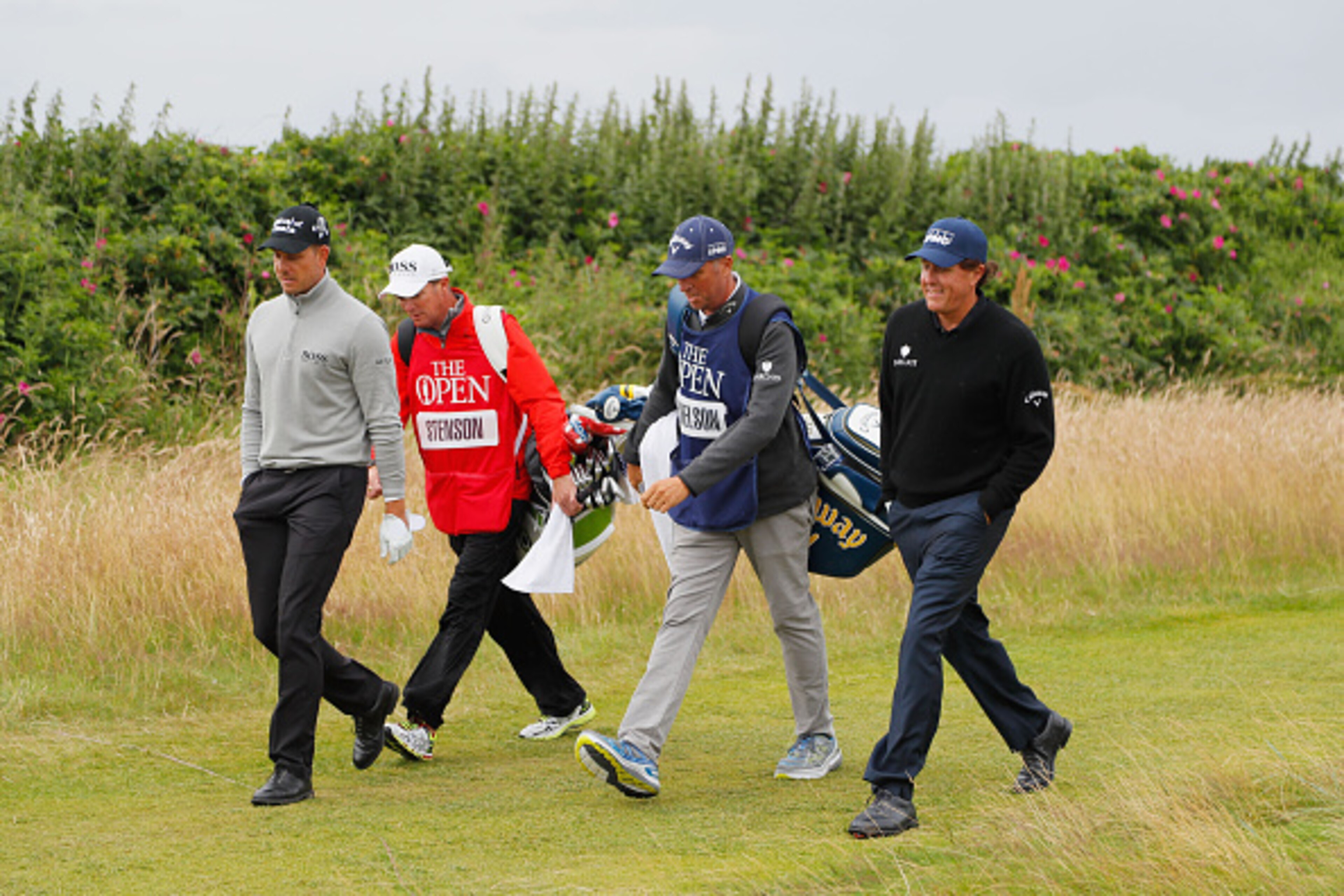 TROON, SCOTLAND - JULY 16:  Henrik Stenson of Sweden and his caddie Gareth Lord and Phil Mickelson of the United States and his caddie Jim McKay are pictured during the third round on day three of the 145th Open Championship at Royal Troon on July 16, 201