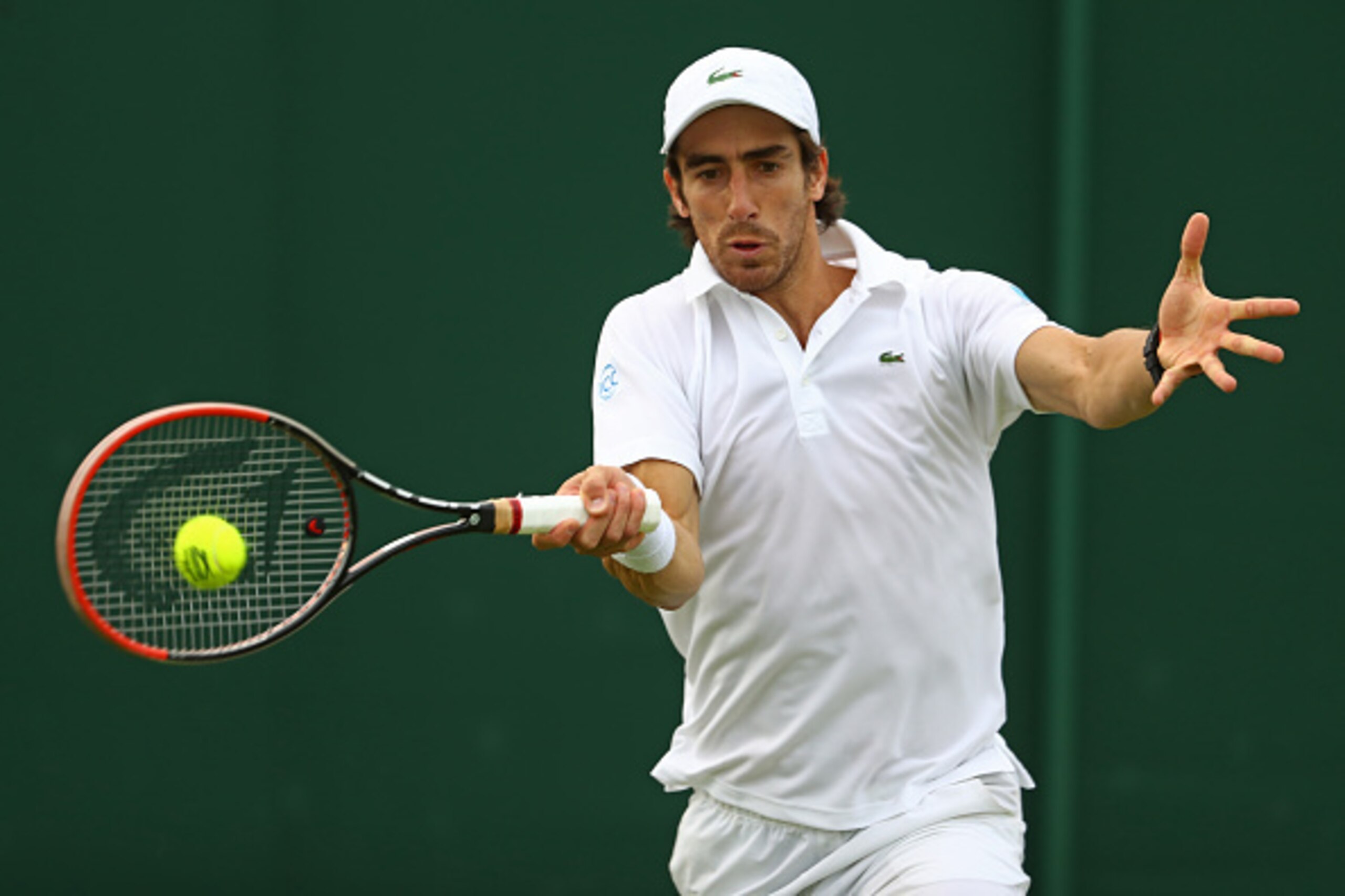LONDON, ENGLAND - JUNE 27: Pablo Cuevas of Uraguay plays a forehand shot during the Men's Singles first round match against Andrey Kuznetsov of Russia on day one of the Wimbledon Lawn Tennis Championships at the All England Lawn Tennis and Croquet Club o LONDON, ENGLAND - JUNE 27: Pablo Cuevas of Uraguay plays a forehand shot during the Men's Singles first round match against Andrey Kuznetsov of Russia on day one of the Wimbledon Lawn Tennis Championships at the All England Lawn Tennis and Croquet Club o