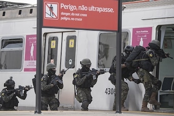 Brazilian army special forces assigned to the security of the Rio 2016 Olympics Games train along idle carriages at the Deodoro train station in Rio de Janeiro, Brazil on July 16, 2016. / AFP / CHRISTOPHE SIMON        (Photo credit should read CHRISTOPHE 
