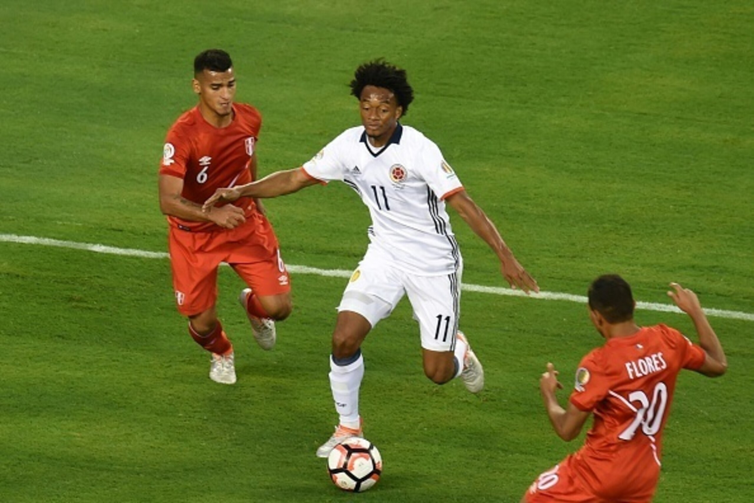 Colombia's Juan Cuadrado controls the ball marked by Peru's Miguel Trauco(L)and Peru's Edison Flores(R)during their Copa America Centenario quarterfinal football match in East Rutherford, New Jersey, United States, on June 17, 2016.  / AFP / DON EMMERT   