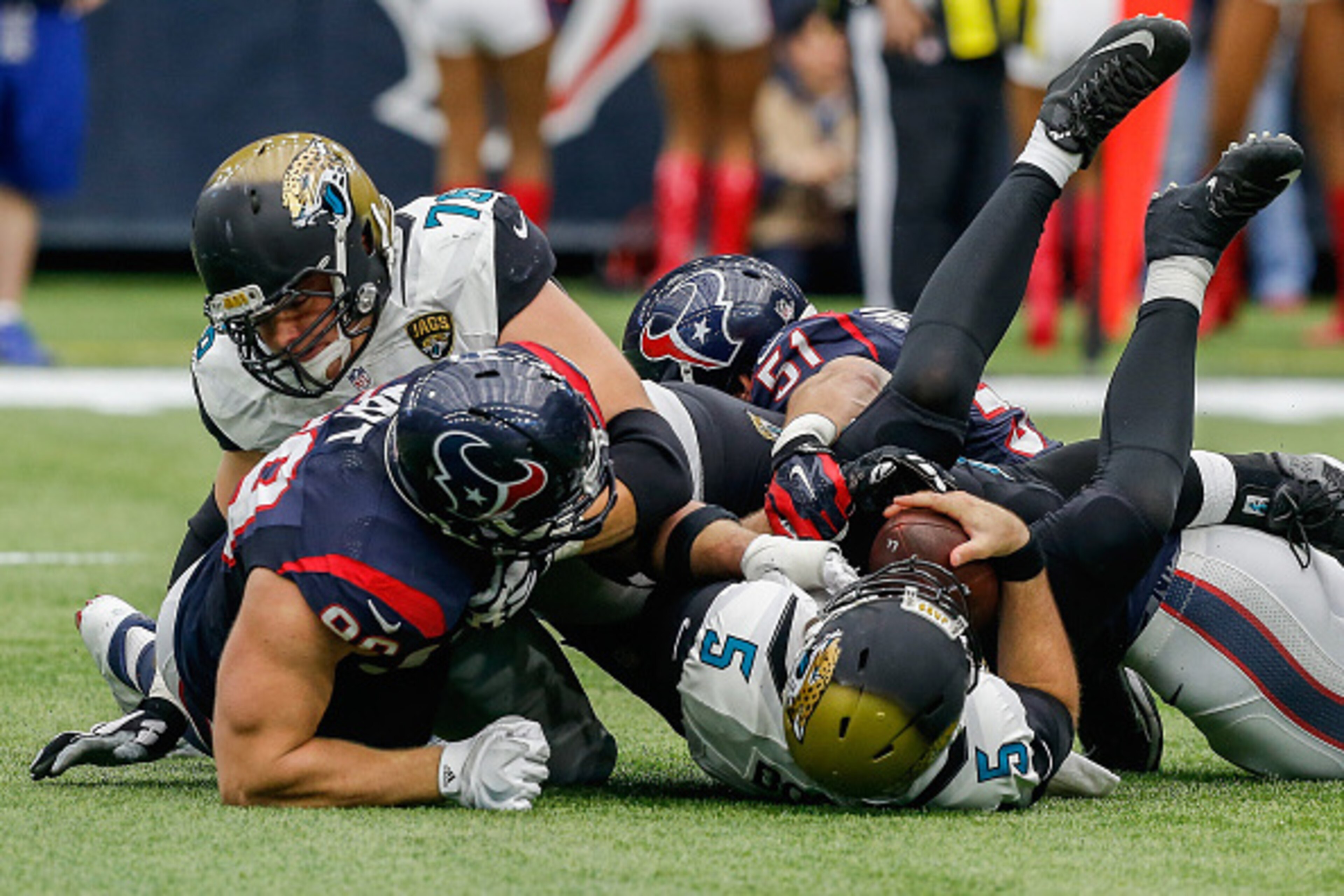 HOUSTON, TX - JANUARY 03:  Blake Bortles #5 of the Jacksonville Jaguars is sacked by J.J. Watt #99 of the Houston Texans along with John Simon #51 and Whitney Mercilus #59 as Luke Joeckel #76 of the Jacksonville Jaguars attempts to block at NRG Stadium on