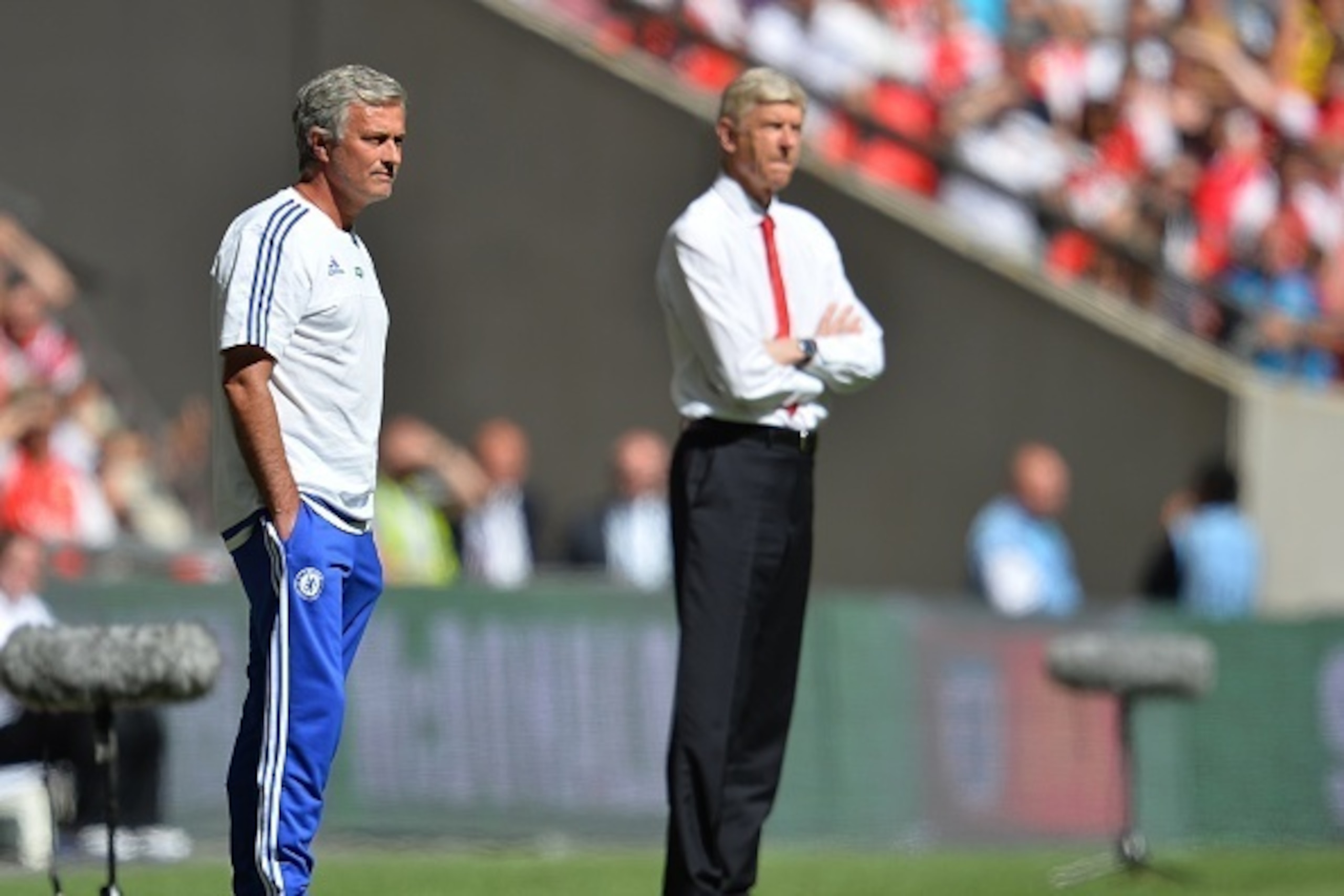 Chelsea's Portuguese manager Jose Mourinho (L) and Arsenal's French manager Arsene Wenger (R) watch from the side during the FA Community Shield football match between Arsenal and Chelsea at Wembley Stadium in north London on August 2, 2015. AFP PHOTO / G