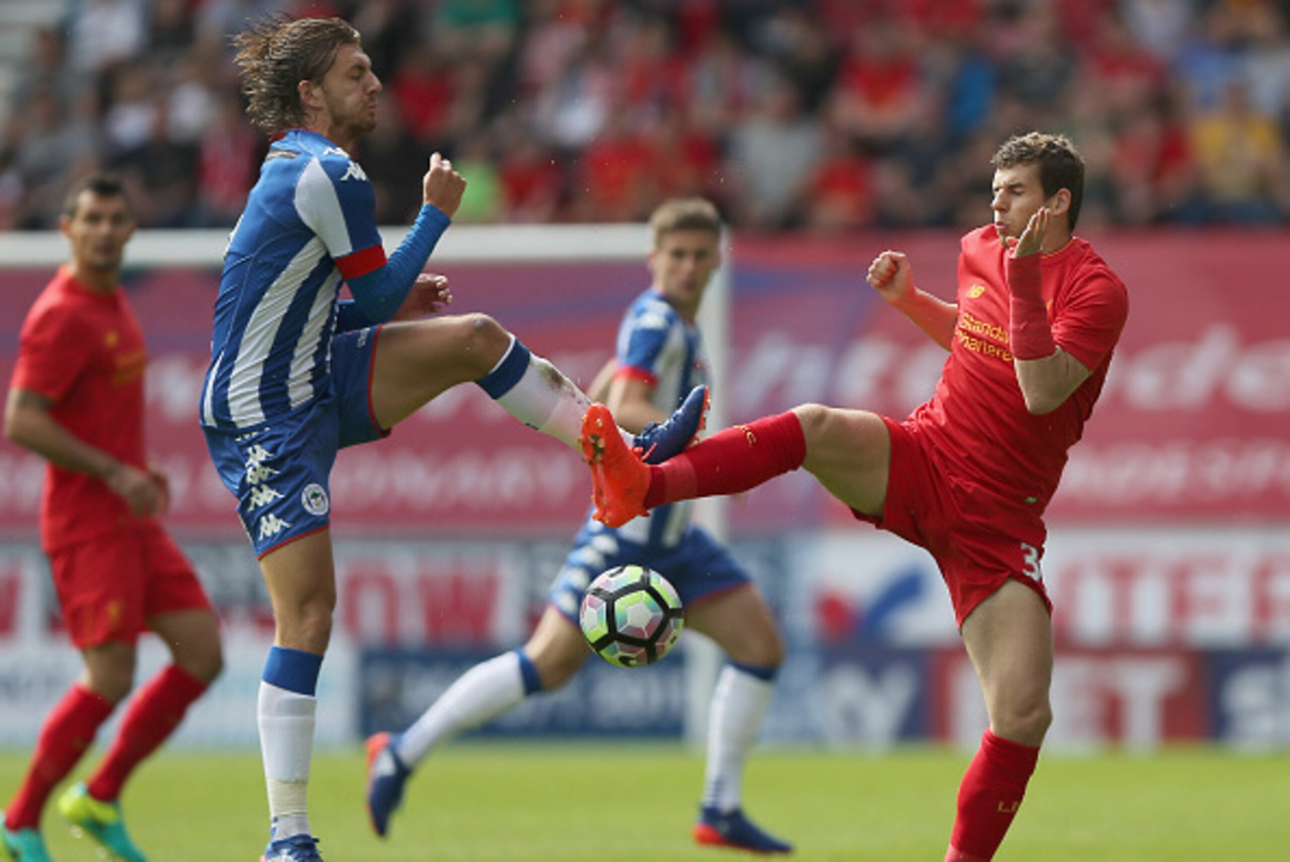 WIGAN, ENGLAND - JULY 17:  Alex Gilby of (L) Wigan Athletic challenges Jon Flanagan of Liverpool during the Pre-Season Friendly match between Wigan Athletic and Liverpool at JJB Stadium on July 17, 2016 in Wigan, England.  (Photo by Nigel Roddis/Getty Ima