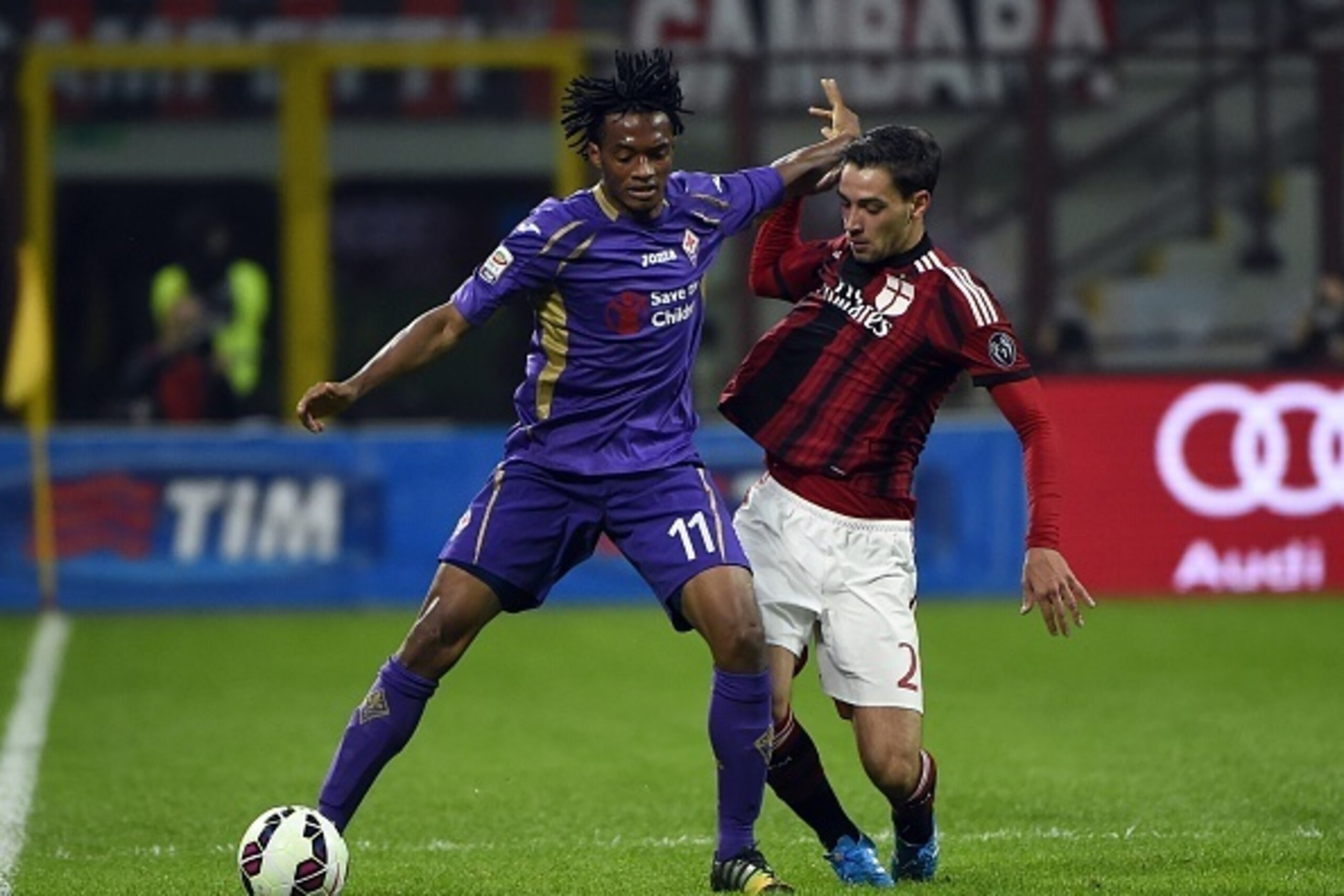 AC Milan's defender Mattia De Sciglio (R) fights for the ball with Fiorentina's forward from Colombia Juan Cuadrado during the Italian Serie A football match AC Milan vs Fiorentina on October 26, 2014 at the San Siro Stadium stadium in Milan. AFP PHOTO / 