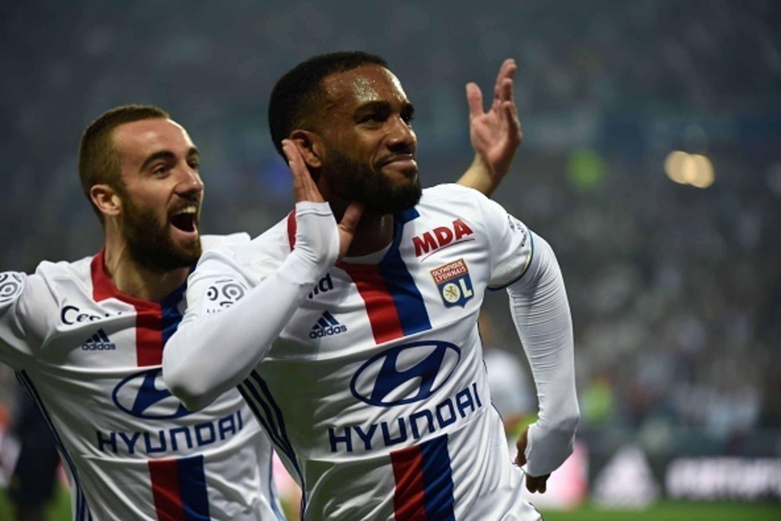 Lyon's French forward Alexandre Lacazette (C) celebrates after scoring next to teammate Lyon's Spanish midfielder Sergi Darder (L) during the French L1 football match Olympique Lyonnais and AS Monaco on May 7, 2016, at the New Stadium in Decines-Charpieu 