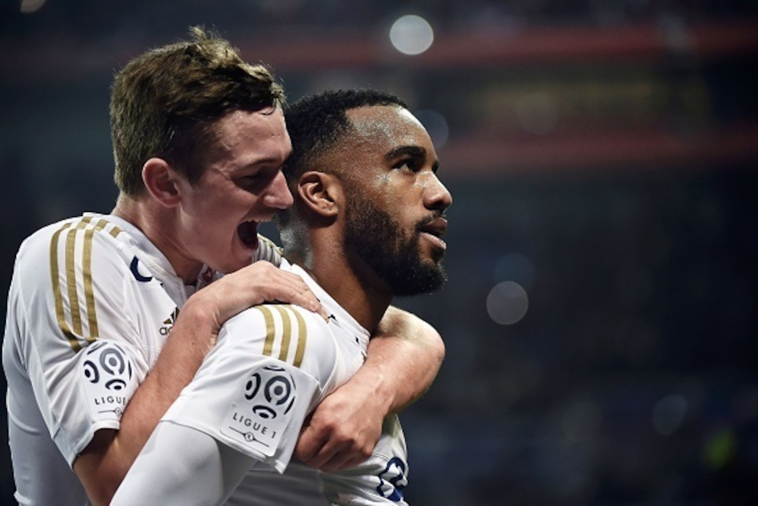 Lyon's French forward Alexandre Lacazette celebrates with teammate Gaetan Perrin (L) after scoring a goal during the French L1 football match between Lyon and Nantes at the New Stadium in Decines-Charpieu, central-eastern France, on March 19, 2016. AFP PH