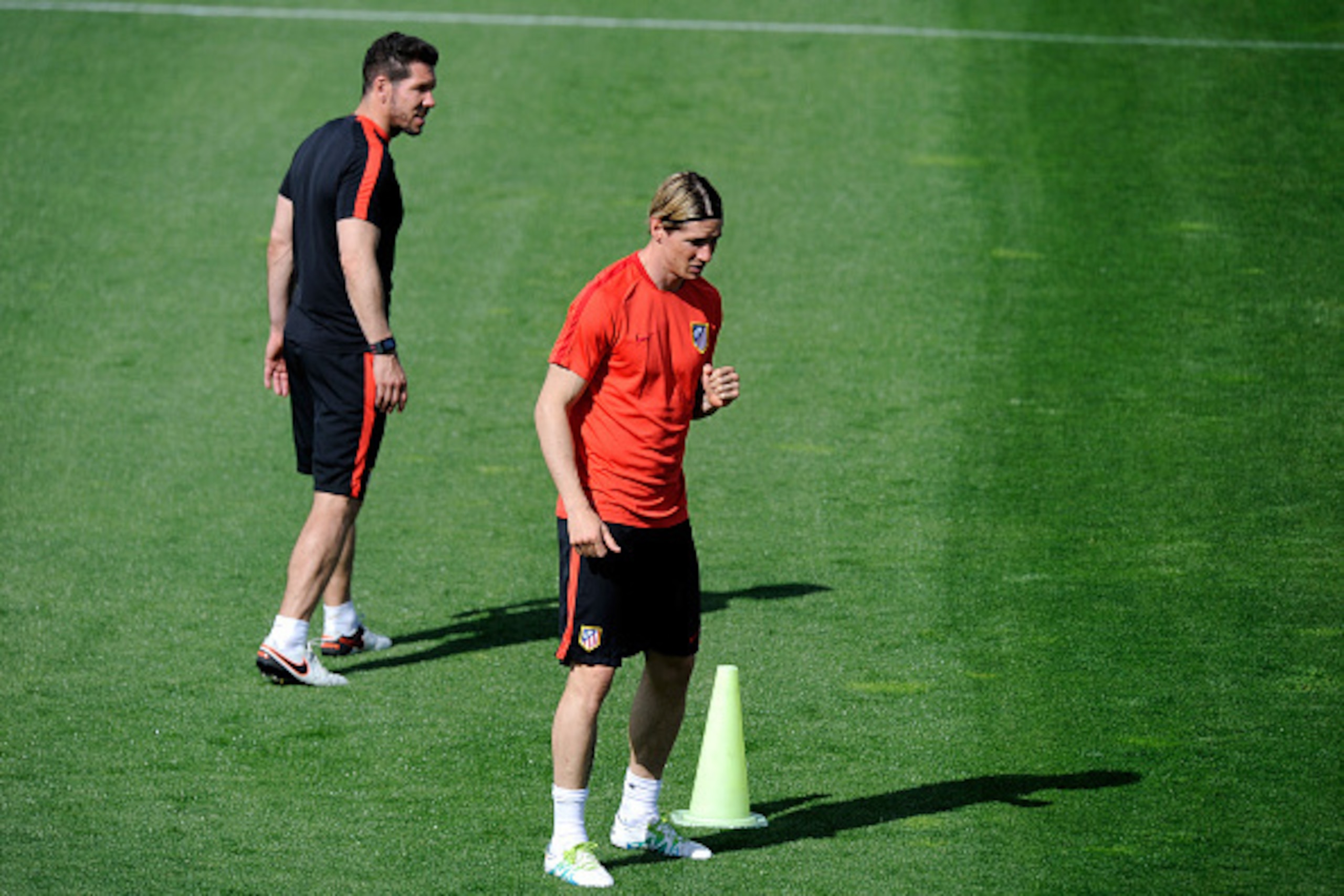 MADRID, SPAIN - APRIL 26: Fernando Torres of Atletico Madrid waits for the ball as Diego Simeone, Manager of Atletico Madrid watches during a training session ahead of the UEFA Champions League Semi-Final First Leg between Club Atletico de Madrid and Bay MADRID, SPAIN - APRIL 26: Fernando Torres of Atletico Madrid waits for the ball as Diego Simeone, Manager of Atletico Madrid watches during a training session ahead of the UEFA Champions League Semi-Final First Leg between Club Atletico de Madrid and Bay