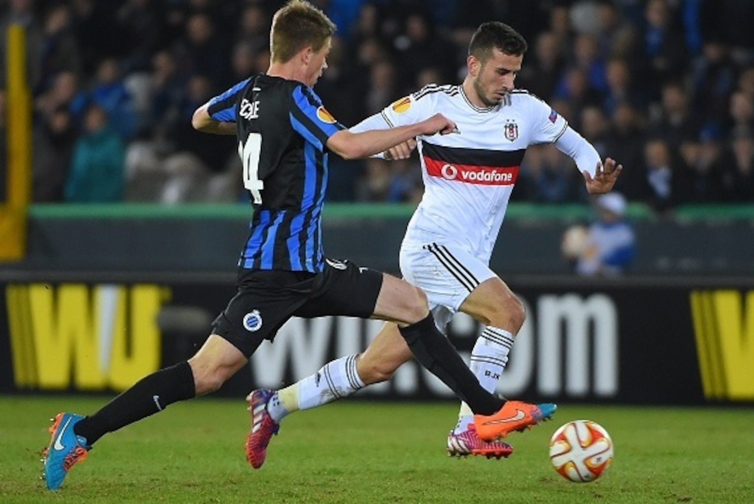 Besiktas' midfielder  Oguzhan Ozyakup (R) drives the ball past Club Brugge's defender Brandon Mechele during in the UEFA Europa League round of 16 match between Club Brugge KV  and Besiktas JK in Bruges on March 12, 2015. AFP PHOTO/EMMANUEL DUNAND        
