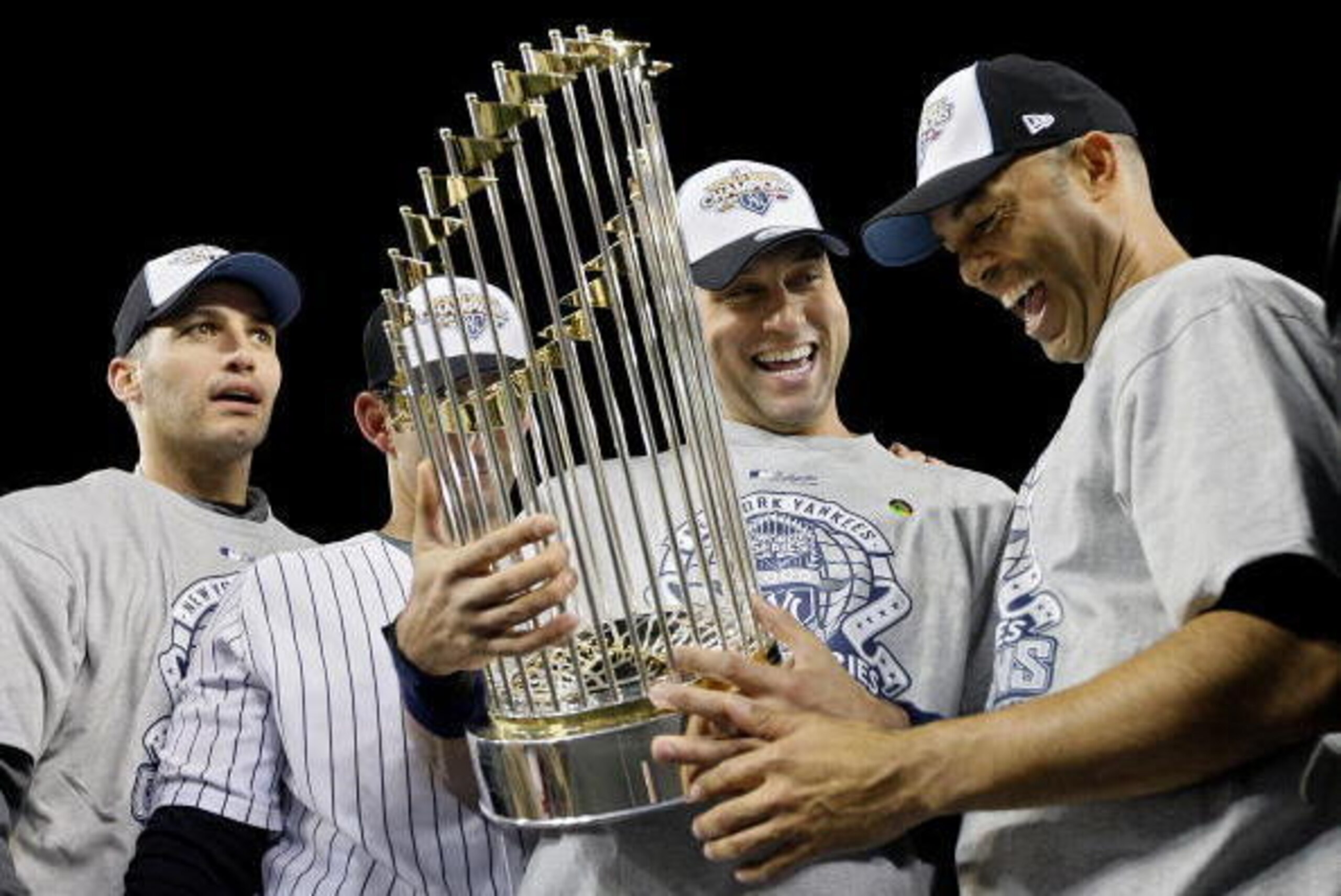 NEW YORK - NOVEMBER 04:  (L-R) Andy Pettitte #46, Jorge Posada #20, Derek Jeter #2 and Mariano Rivera #42 of the New York Yankees celebrate with the trophy after their 7-3 win against the Philadelphia Phillies in Game Six of the 2009 MLB World Series at Y