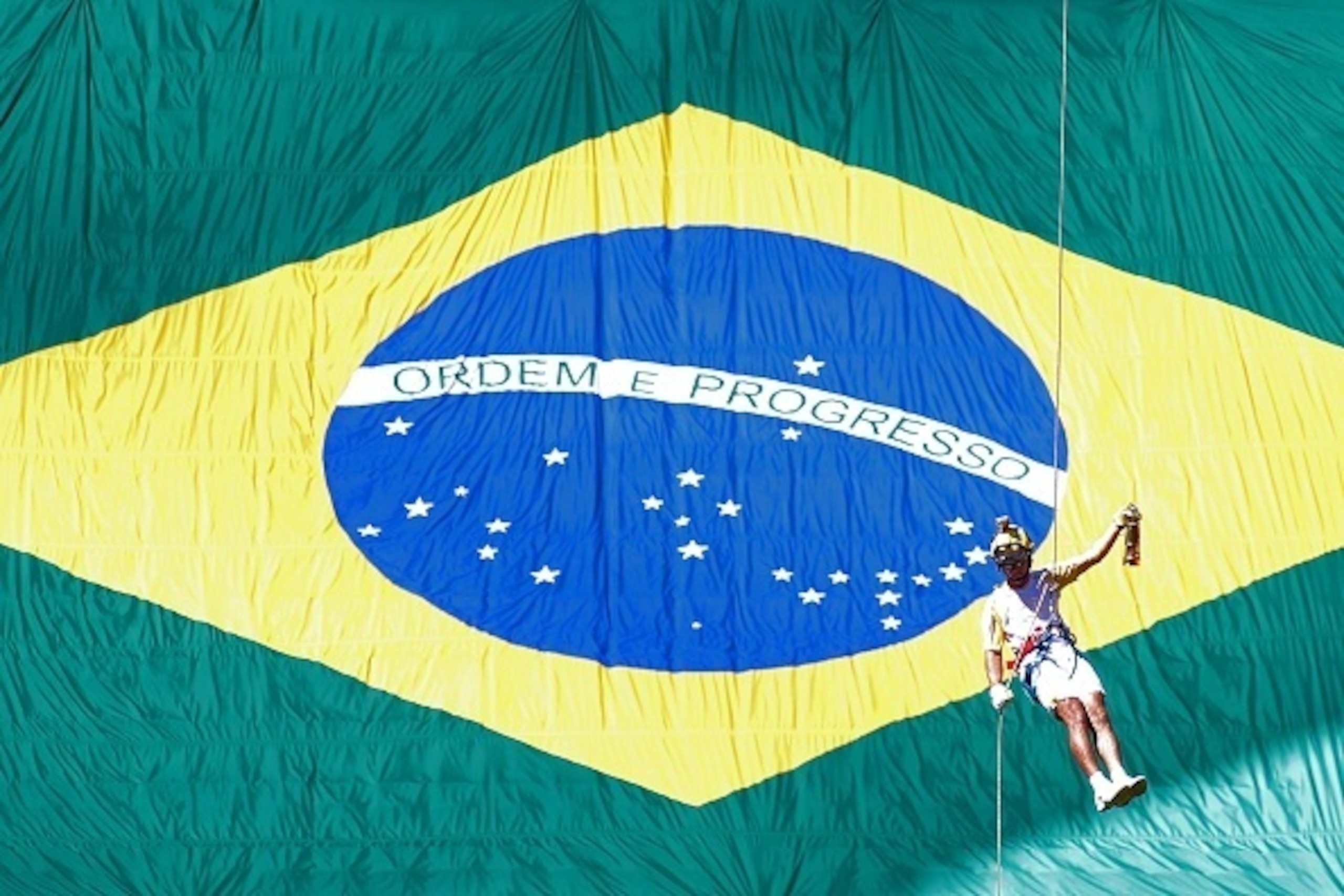 Brazilian fireman Haudson Alves descends from a helicopter carrying the Olympic flame on a lantern at the Brasilia National Stadium in Brasilia on May 3, 2016.
Embattled President Dilma Rousseff greeted the Olympic flame in Brazil on Tuesday, promising no