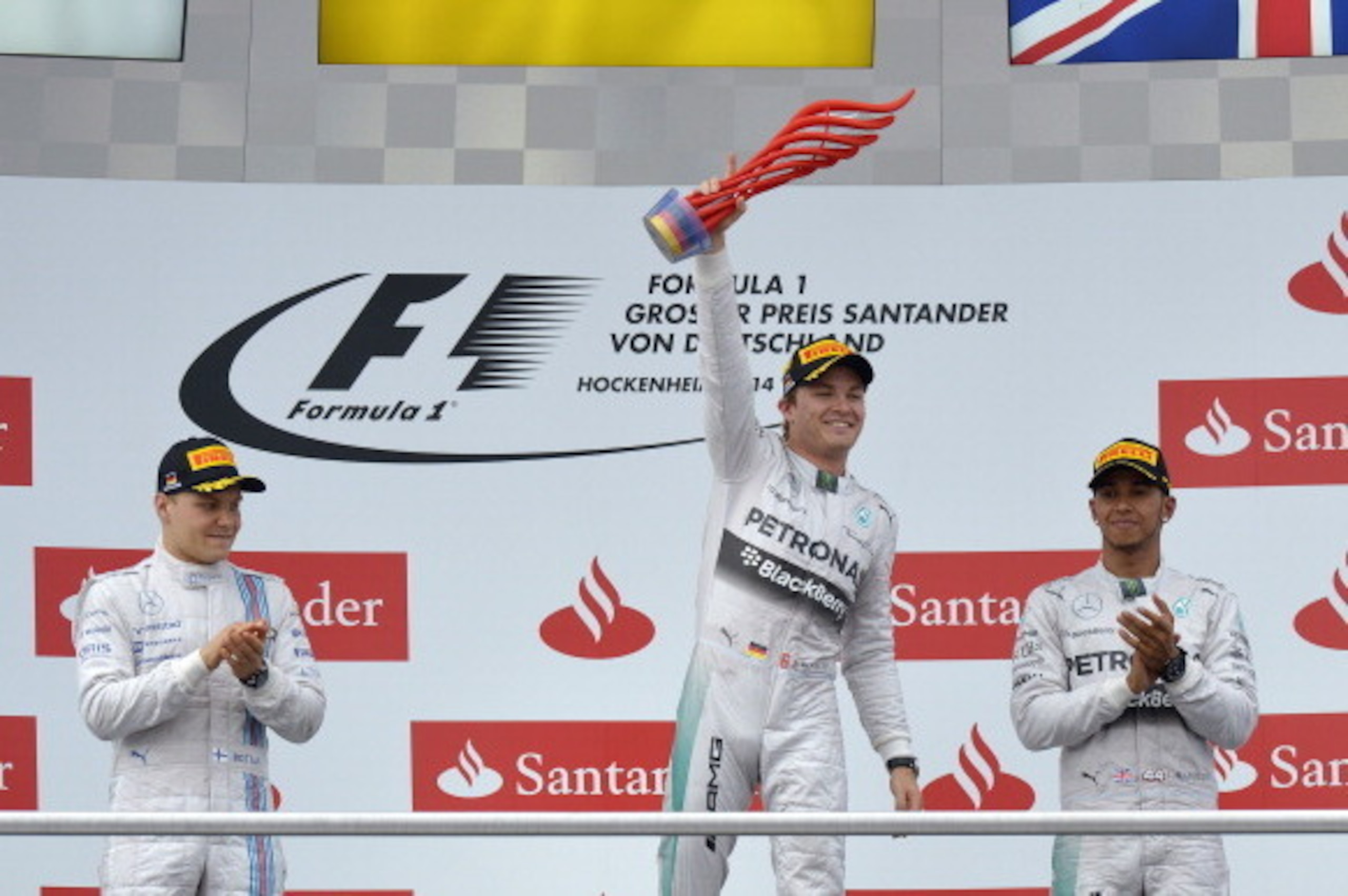 Mercedes-AMG's German driver and race winner Nico Rosberg (C) celebrates next to second placed Williams' Finnish driver Valtteri Bottas (L) and Mercedes' British driver Lewis Hamilton (R) after the German Formula One Grand Prix at the Hockenheimring racin