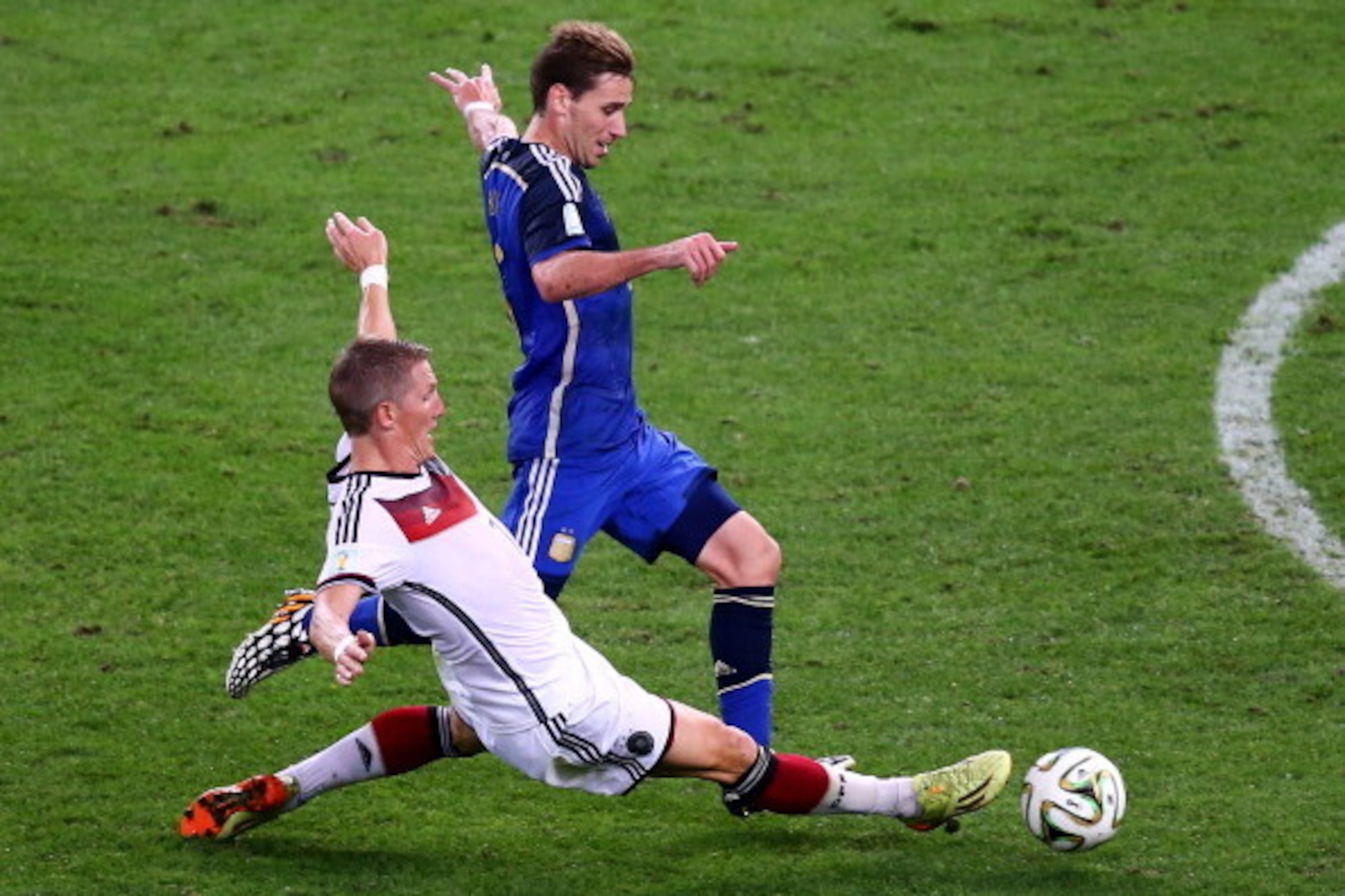 RIO DE JANEIRO, BRAZIL - JULY 13:  Bastian Schweinsteiger of Germany tackles Lucas Biglia of Argentina during the 2014 FIFA World Cup Brazil Final match between Germany and Argentina at Maracana on July 13, 2014 in Rio de Janeiro, Brazil.  (Photo by Rober