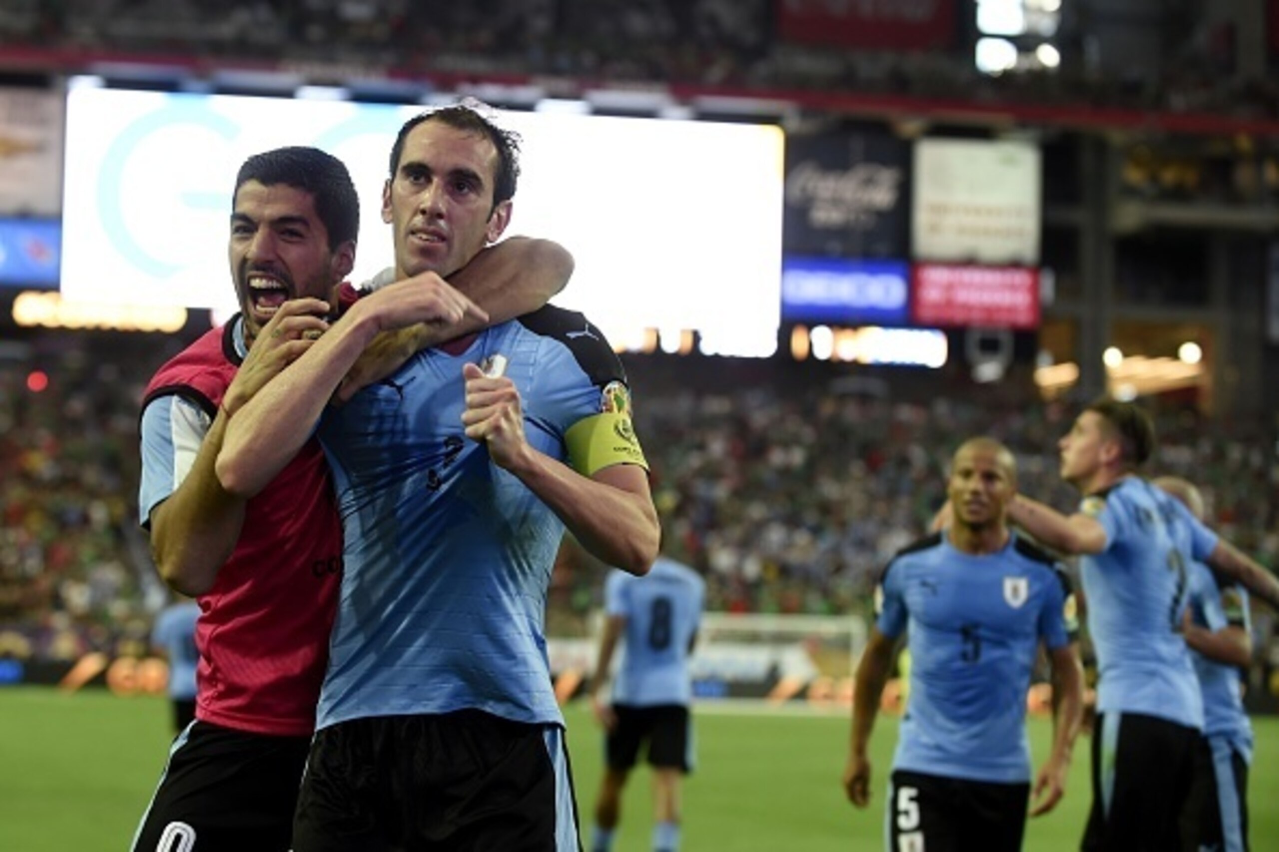 Uruguay's Diego Godin (R) celebrates with teammate Luis Suarez after scoring against Mexico during their Copa America Centenario football tournament match in Glendale, Arizona, United States, on June 5, 2016.  / AFP / ALFREDO ESTRELLA        (Photo credit