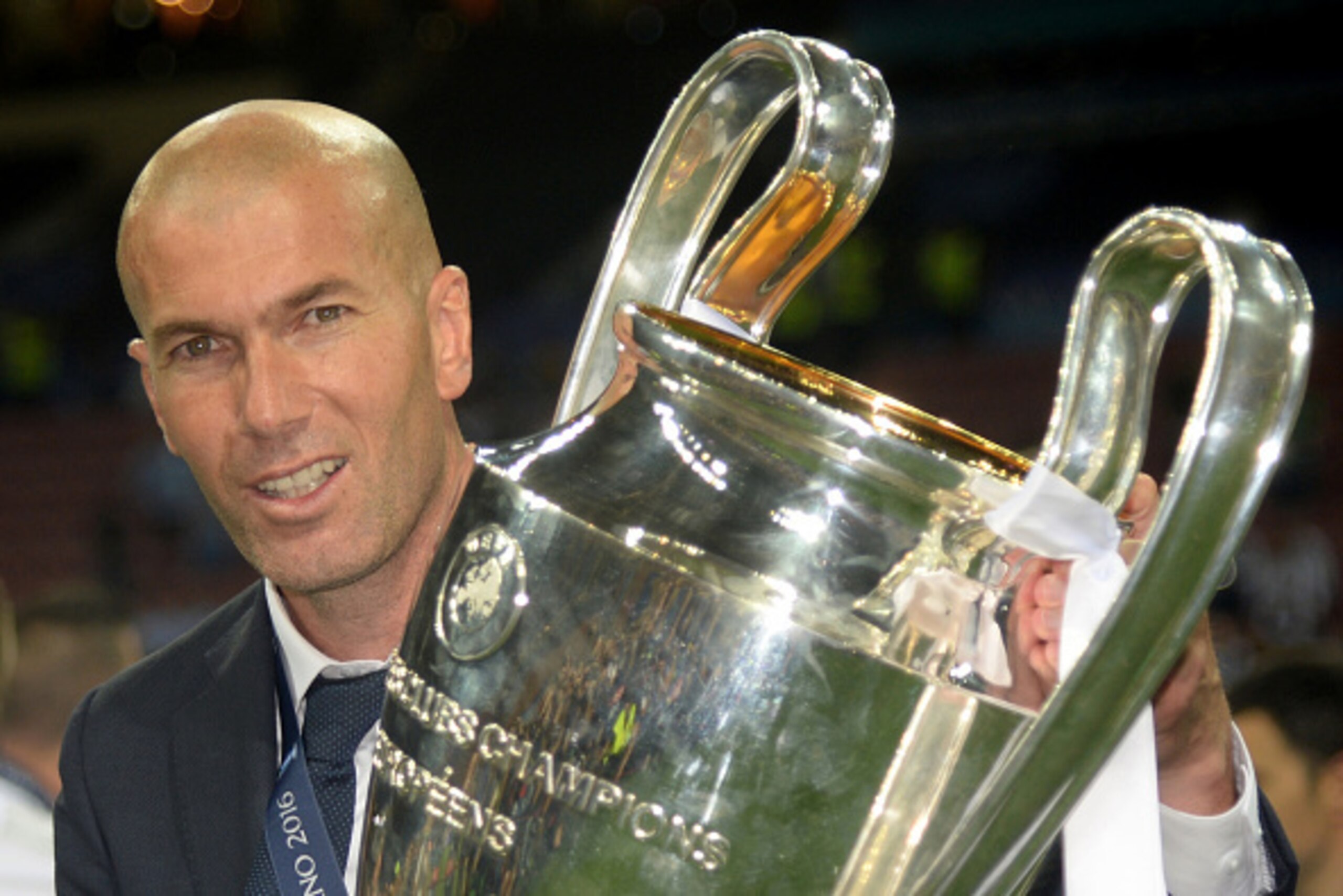 Real Madrid's French coach Zinedine Zidane poses with the trophy after Real Madrid won the UEFA Champions League final football match between Real Madrid and Atletico Madrid at San Siro Stadium in Milan, on May 28, 2016. / AFP / Filippo MONTEFORTE        