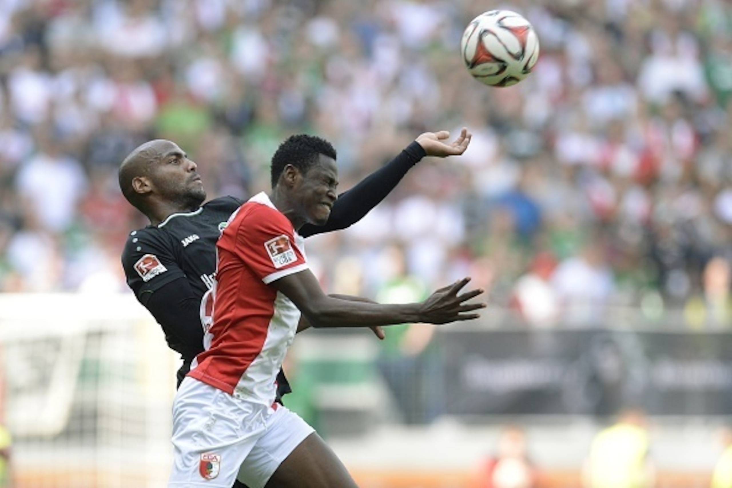 Hanover's French striker Jimmy Briand (L) and Augsburg's defender Abdul Rahman Baba vie for the ball during the German first division Bundesliga football match FC Augsburg vs Hannover 96 in Augsburg, southern Germany, on May 16, 2015.  AFP PHOTO / CHRISTO