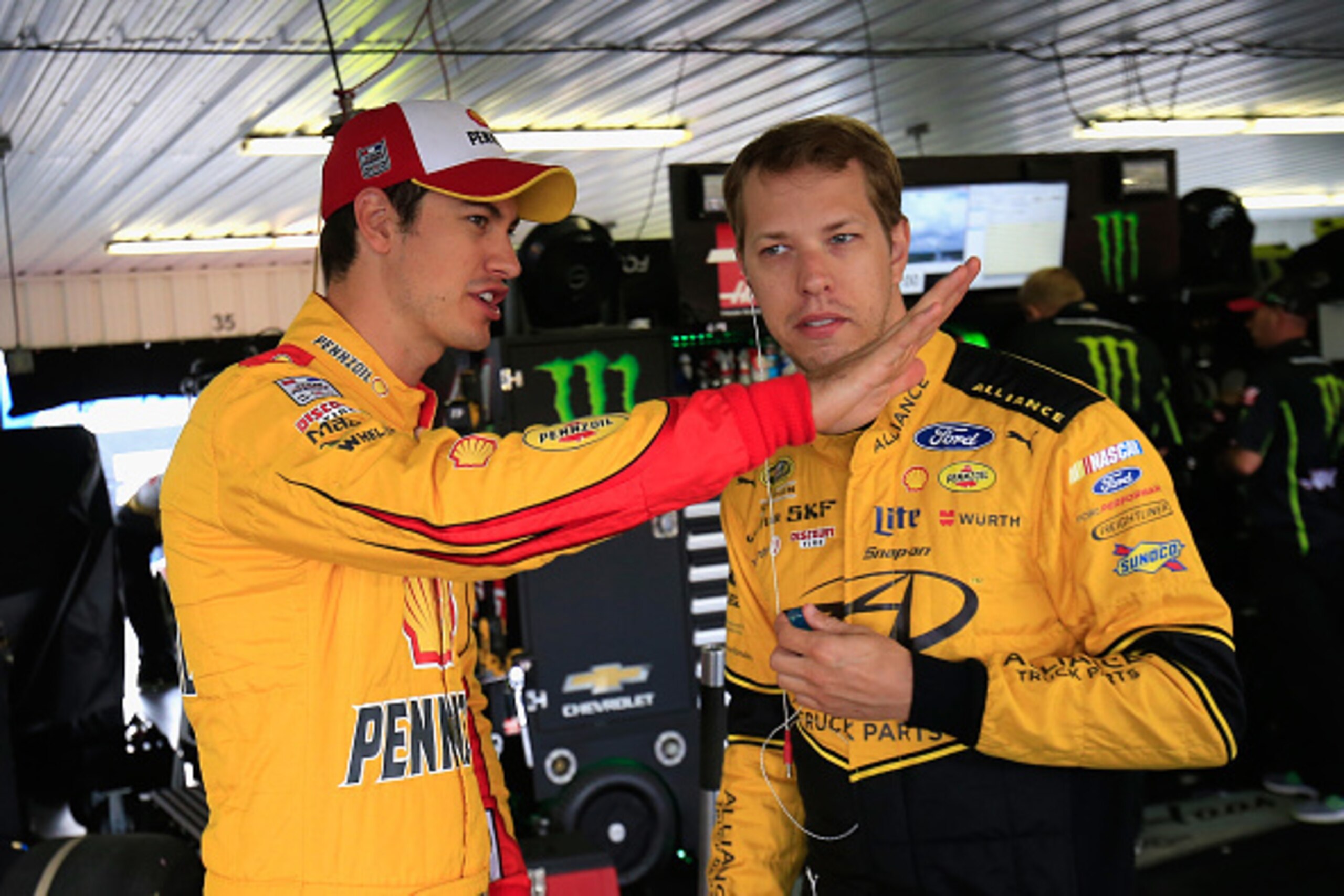 LONG POND, PA - JULY 29:  (L-R) Teammates Joey Logano, driver of the #22 Shell Pennzoil Ford, and Brad Keselowski, driver of the #2 Alliance Truck Parts Ford, talk in the garage area during practice for the NASCAR Sprint Cup Series Pennsylvania 400 at Poc