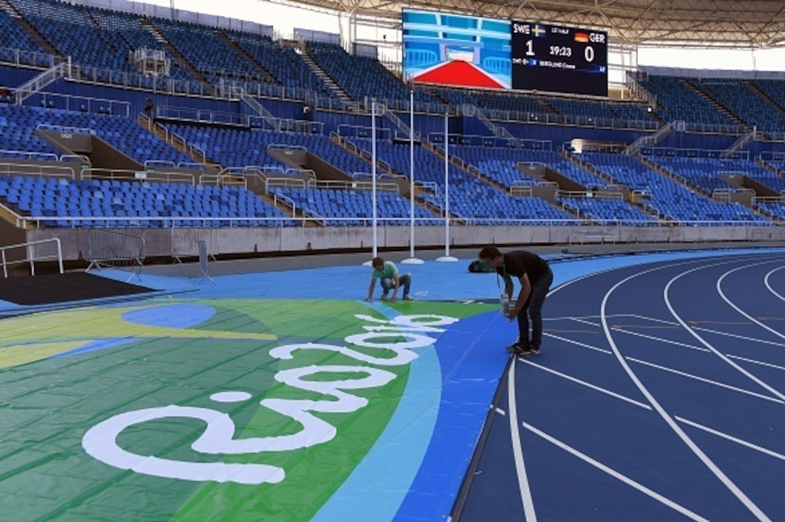 Workers apply the finishing touches to the Olympic Stadium in Rio de Janeiro on August 2, 2016, ahead of the Rio 2016 Olympic Games.  / AFP / VANDERLEI ALMEIDA        (Photo credit should read VANDERLEI ALMEIDA/AFP/Getty Images)
