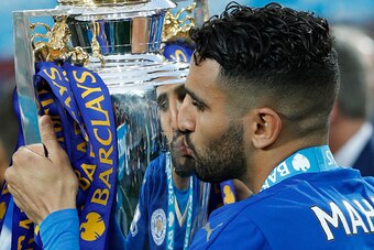 Leicester City's Algerian midfielder Riyad Mahrez kisses the premier league trophy after winning the league and the English Premier League football match between Leicester City and Everton at King Power Stadium in Leicester, central England on May 7, 2016
