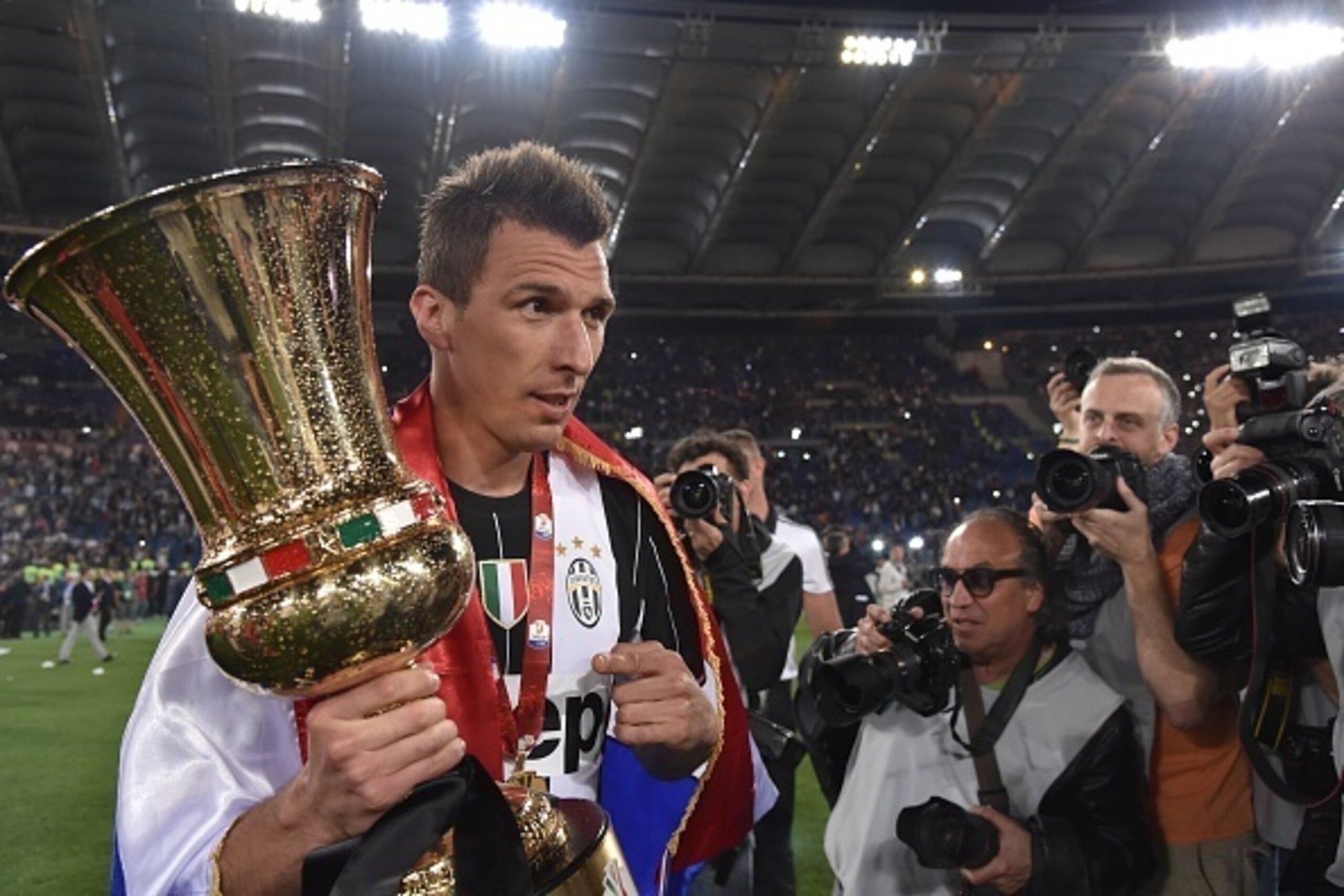 Juventus' forward from Croatia Mario Mandzukic celebrates with the trophy after winning the Italian Tim Cup final football match AC Milan vs Juventus on May 21, 2016 at the Olympic Stadium in Rome.  Juventus won 0-1 in the extra time.     AFP PHOTO / TIZI