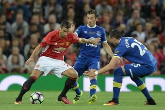 Manchester United's Armenian midfielder Henrikh Mkhitaryan (L) takes on Everton's English defender Leighton Baines (C) and Everton's Argentinian defender Ramiro Funes Mori (R) during the friendly Wayne Rooney testimonial football match between Manchester 