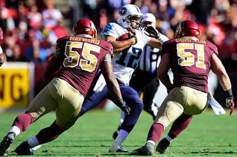 LANDOVER, MD - OCTOBER 19:  Charlie Whitehurst #12 of the Tennessee Titans scrambles against Adam Hayward #55 and Will Compton #51 of the Washington Redskins at FedEx Field on October 19, 2014 in Landover, Maryland.  (Photo by Patrick McDermott/Getty Imag