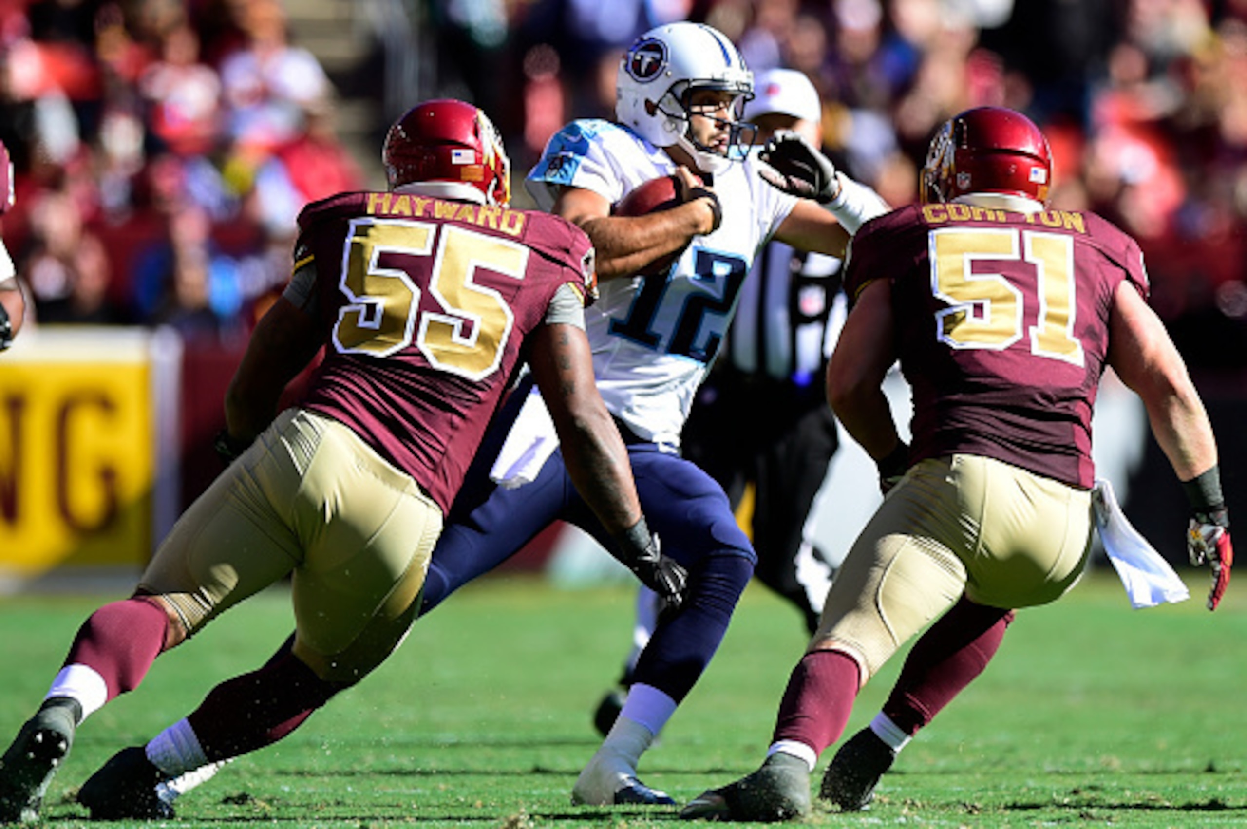 LANDOVER, MD - OCTOBER 19:  Charlie Whitehurst #12 of the Tennessee Titans scrambles against Adam Hayward #55 and Will Compton #51 of the Washington Redskins at FedEx Field on October 19, 2014 in Landover, Maryland.  (Photo by Patrick McDermott/Getty Imag