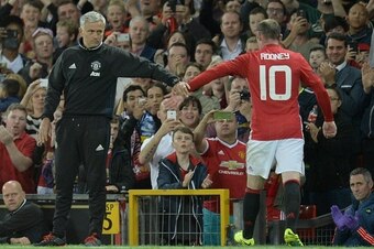 Manchester United's English striker Wayne Rooney (R) touches hands with Manchester United's Portuguese manager Jose Mourinho (L) as he leaves the pitch after being substituted during the friendly Wayne Rooney testimonial football match between Manchester 