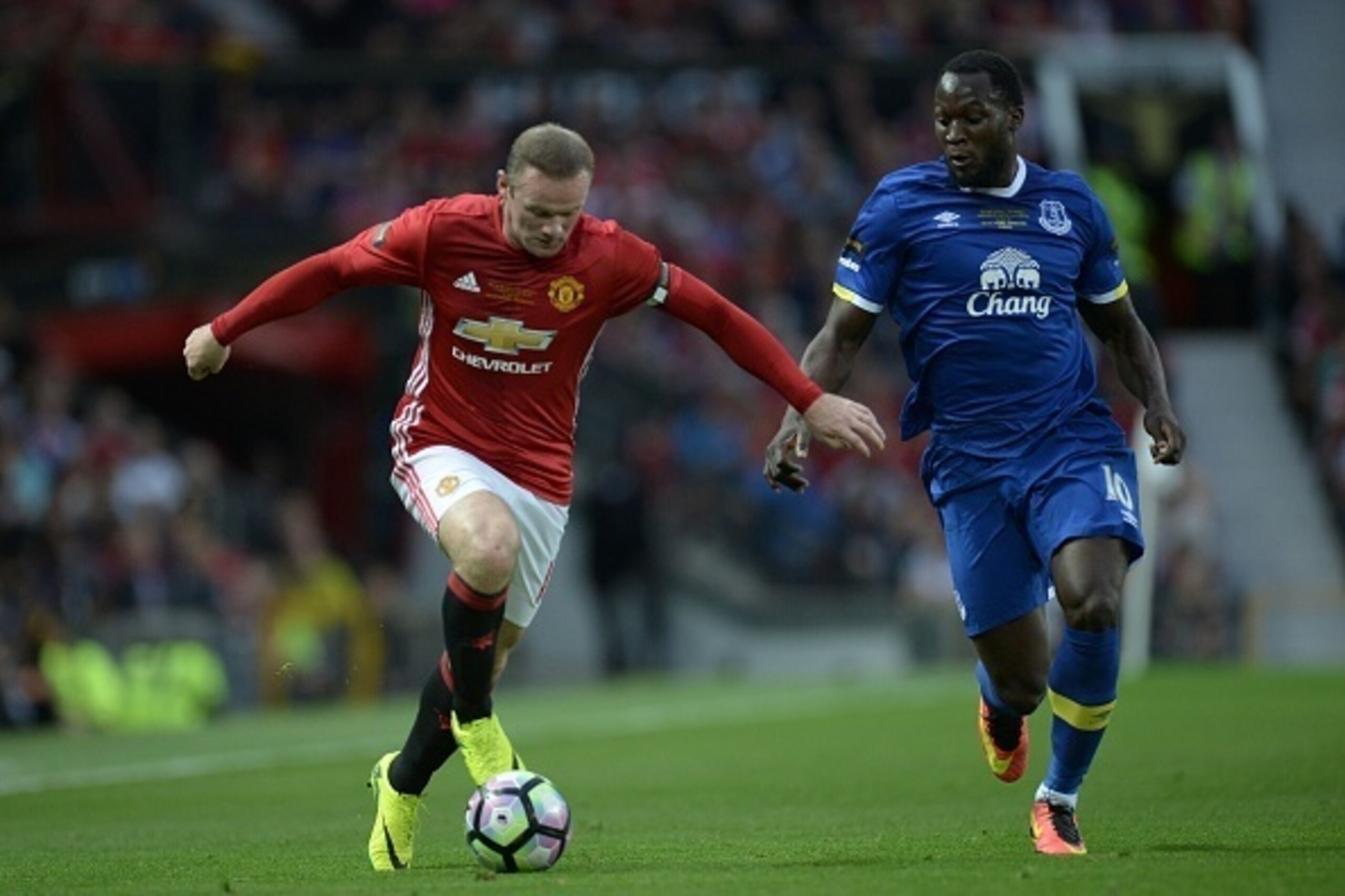 Manchester United's English striker Wayne Rooney (L) runs with the ball challenged by Everton's Belgian striker Romelu Lukaku (R) during the friendly Wayne Rooney testimonial football match between Manchester United and Everton at Old Trafford in Manchest