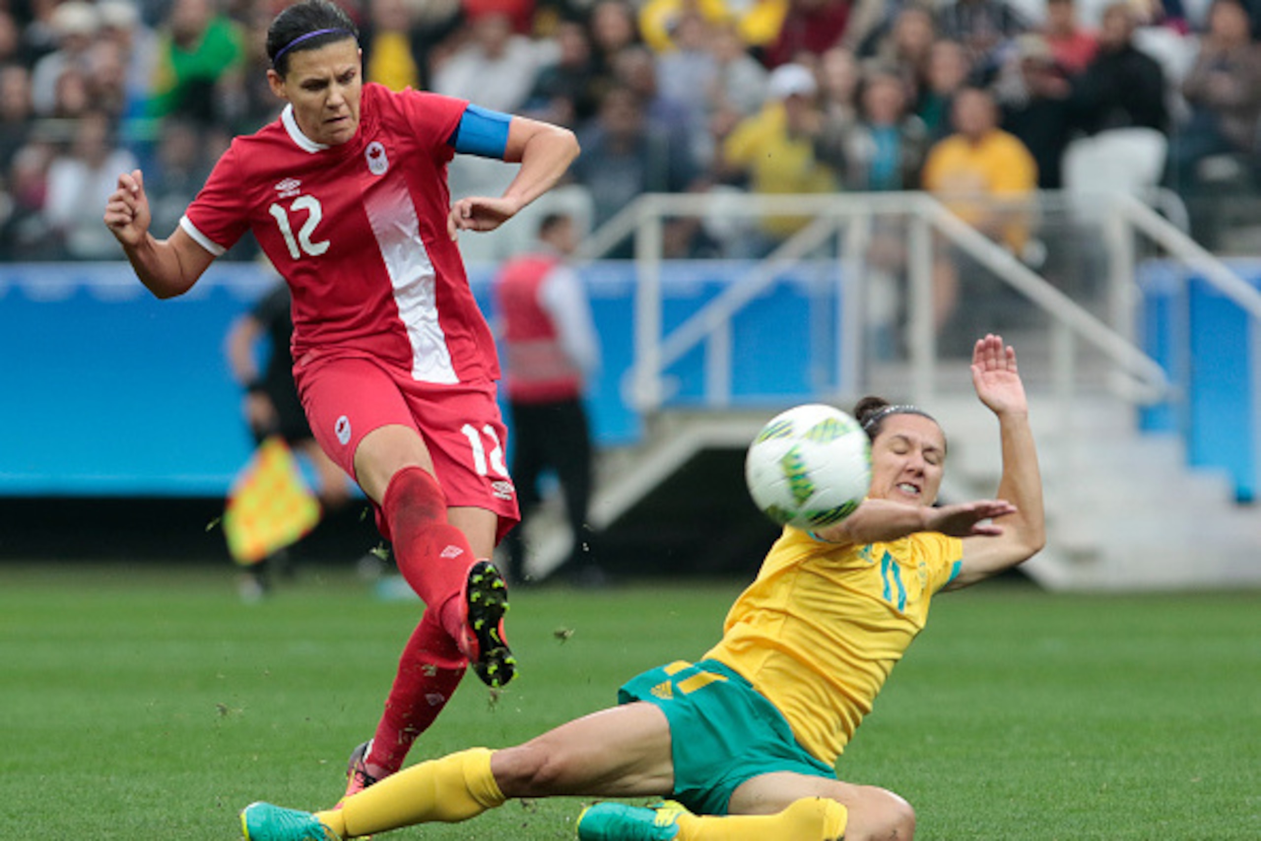Christine Sinclair (L) of Canada kicks the ball to score a goal marked by Lisa de Vanna of Australia during their Rio 2016 Olympic Games group F womens football match held at Corinthians Arena, in Sao Paulo, Brazil, on August 3, 2016. / AFP / Miguel SCHIN