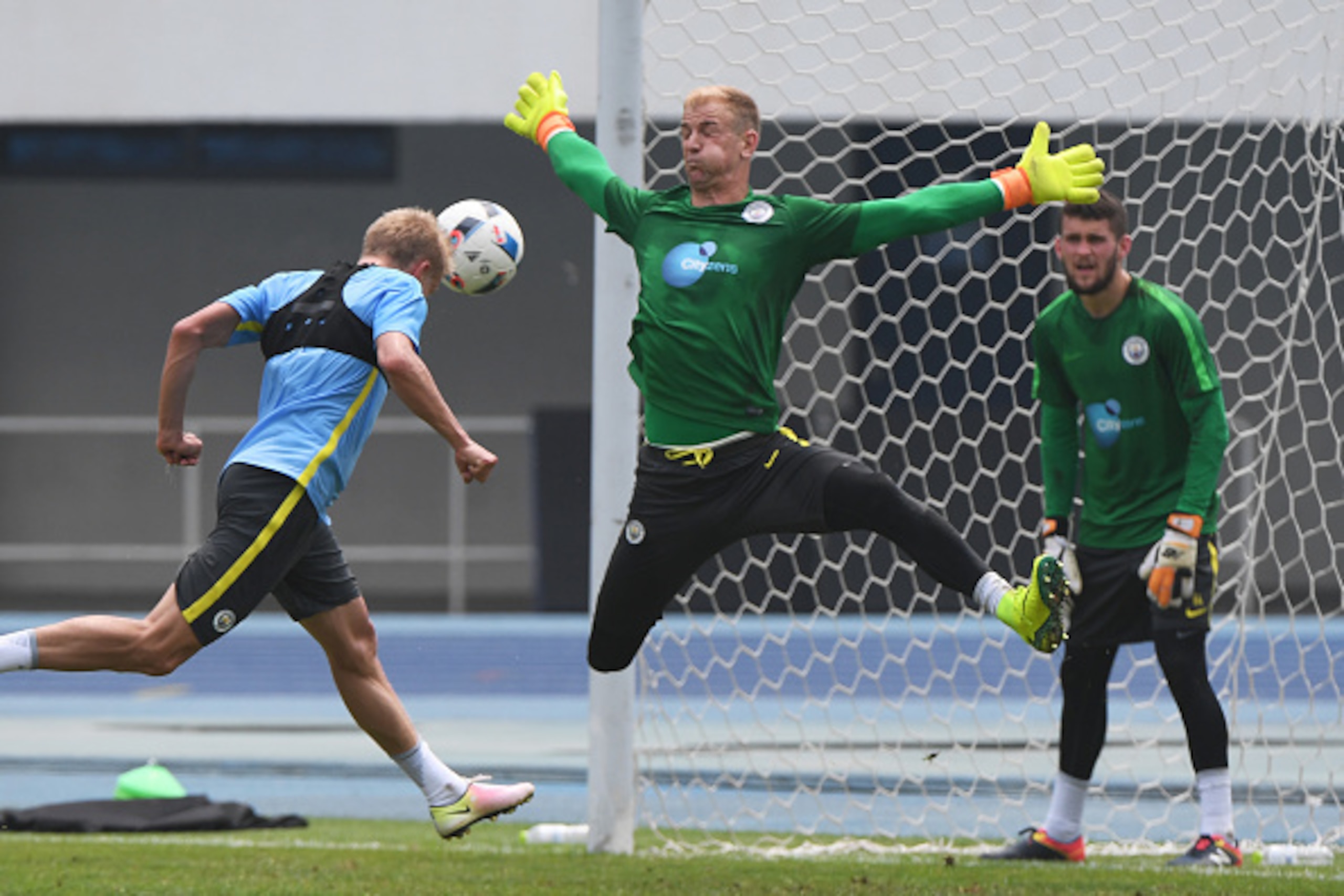 Manchester City goal keeper Joe Hart (C) challenges a player as reserve keeper Angus Gunn (R) looks on during a training session a day before the 2016 International Champions Cup football match between Manchester City and Manchester United, in Beijing on Manchester City goal keeper Joe Hart (C) challenges a player as reserve keeper Angus Gunn (R) looks on during a training session a day before the 2016 International Champions Cup football match between Manchester City and Manchester United, in Beijing on