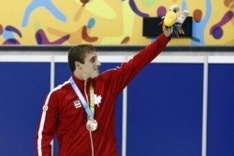Jul 16, 2015; Toronto, Ontario, CAN; Santo Condorelli of Canada waves to the crowd after receiving his bronze medal in the men's swimming 100m butterfly final during the 2015 Pan Am Games at Pan Am Aquatics UTS Centre and Field House. Mandatory Credit: Ro