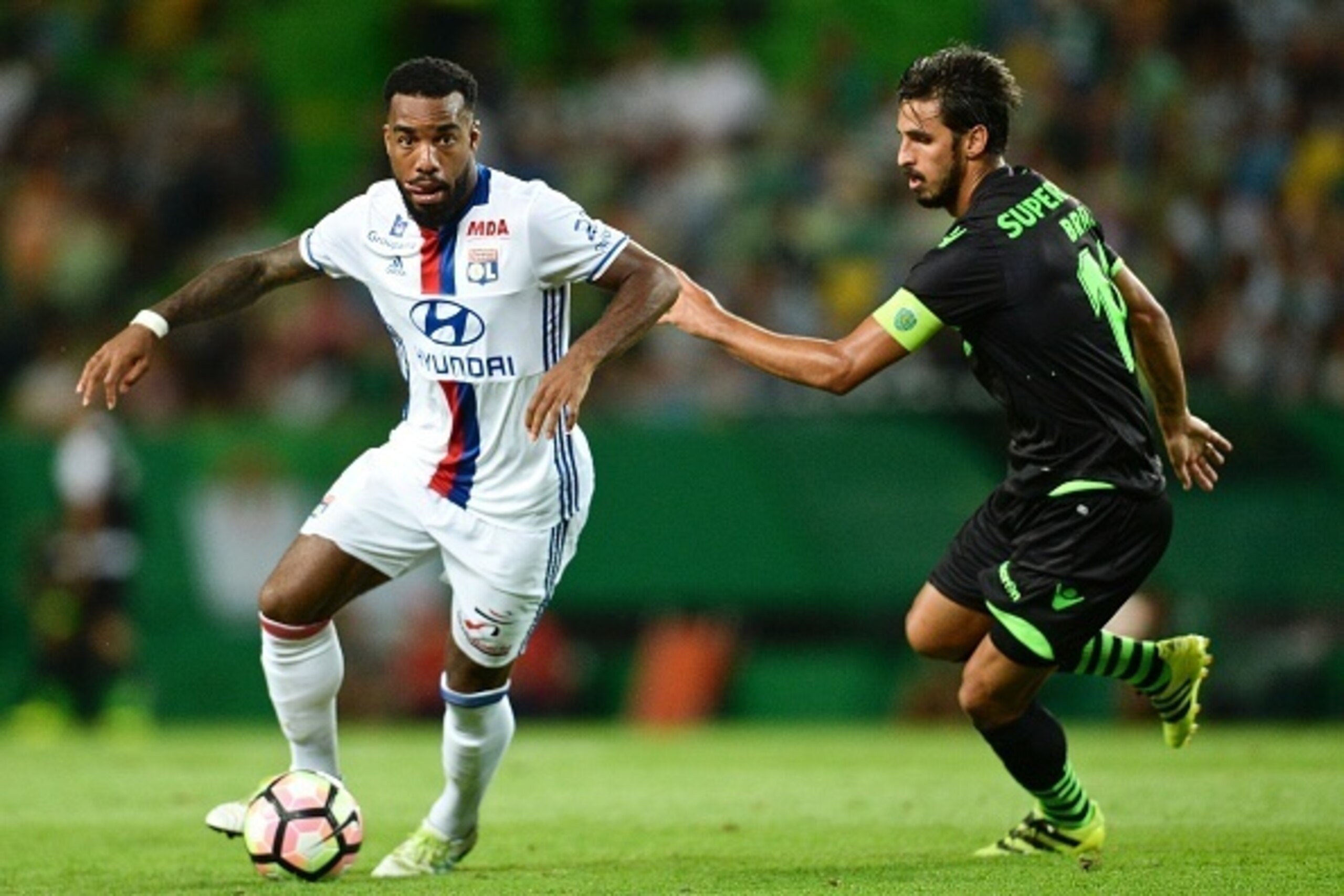 Olympique Lyon's forward Alexandre Lacazette (L) vies with Sporting's Costa Rican forward Bryan Ruiz during the friendly football match Sporting CP vs Olympique de Lyonnais at the Jose Alvalade stadium in Lisbon on July 23, 2016.   / AFP / PATRICIA DE MEL
