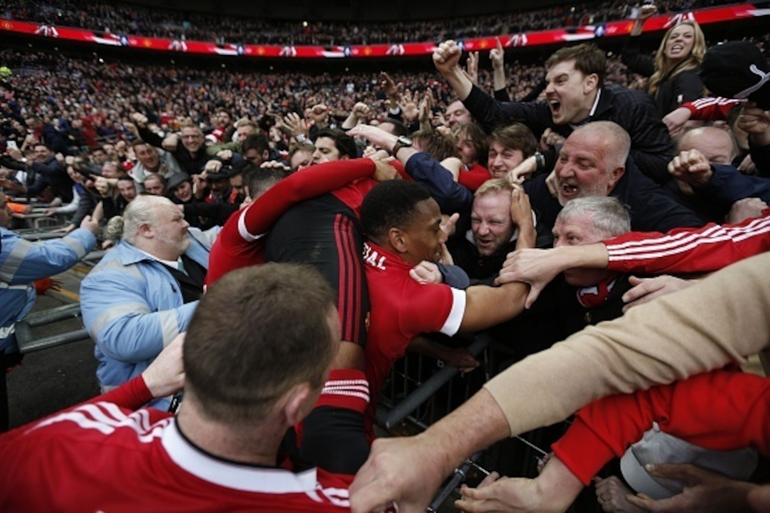 Manchester United's French striker Anthony Martial (C) celebrates in the crowd after scoring their second goal during the English FA Cup semi-final football match between Everton and Manchester United at Wembley Stadium in London on April 23, 2016. / AFP 