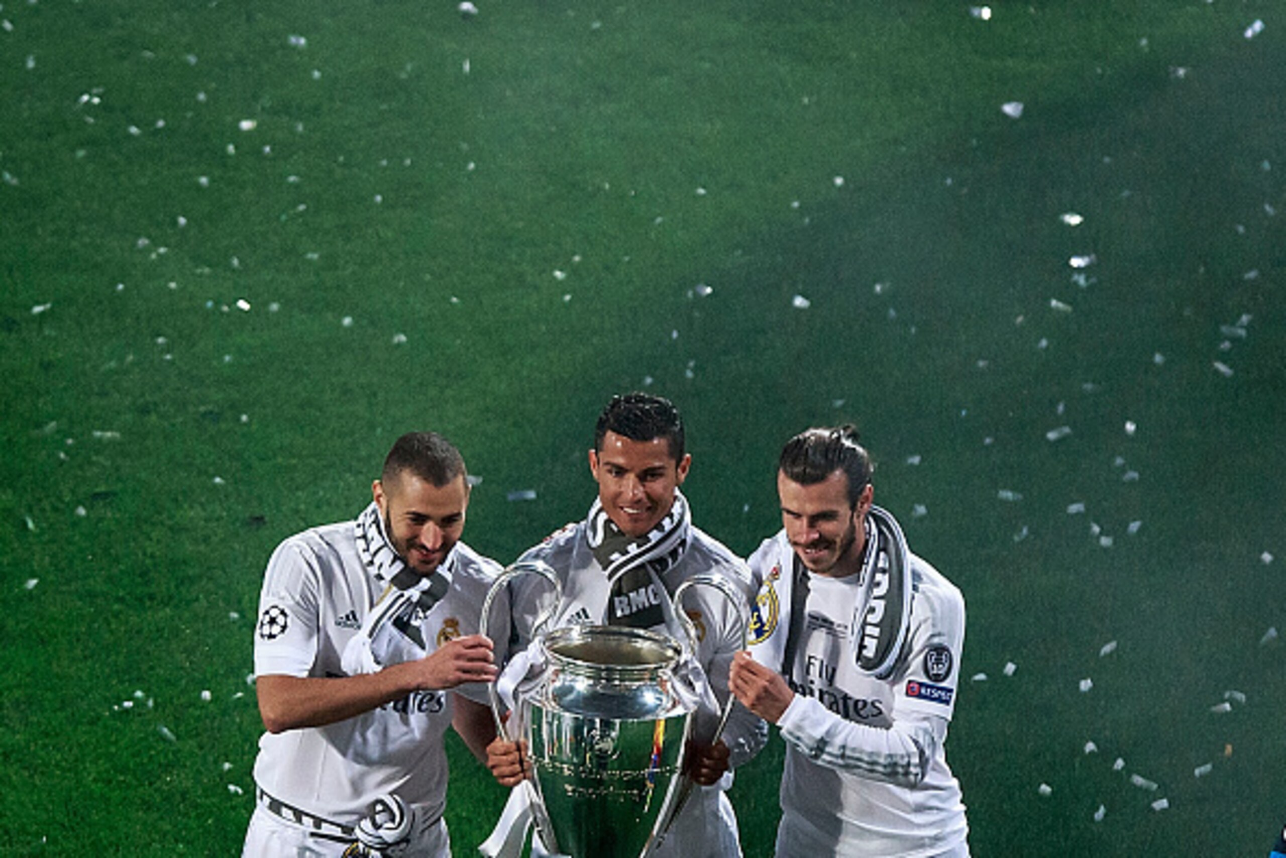 MADRID, SPAIN - MAY 29: Cristiano Ronaldo (2ndL) of Real Madrid CF holds the trophy as he poses for a picture with his teammates Karim Benzema (L) and Gareth Bale (R) during the celebration with their fans at Santiago Bernabeu Stadium the day after winnin
