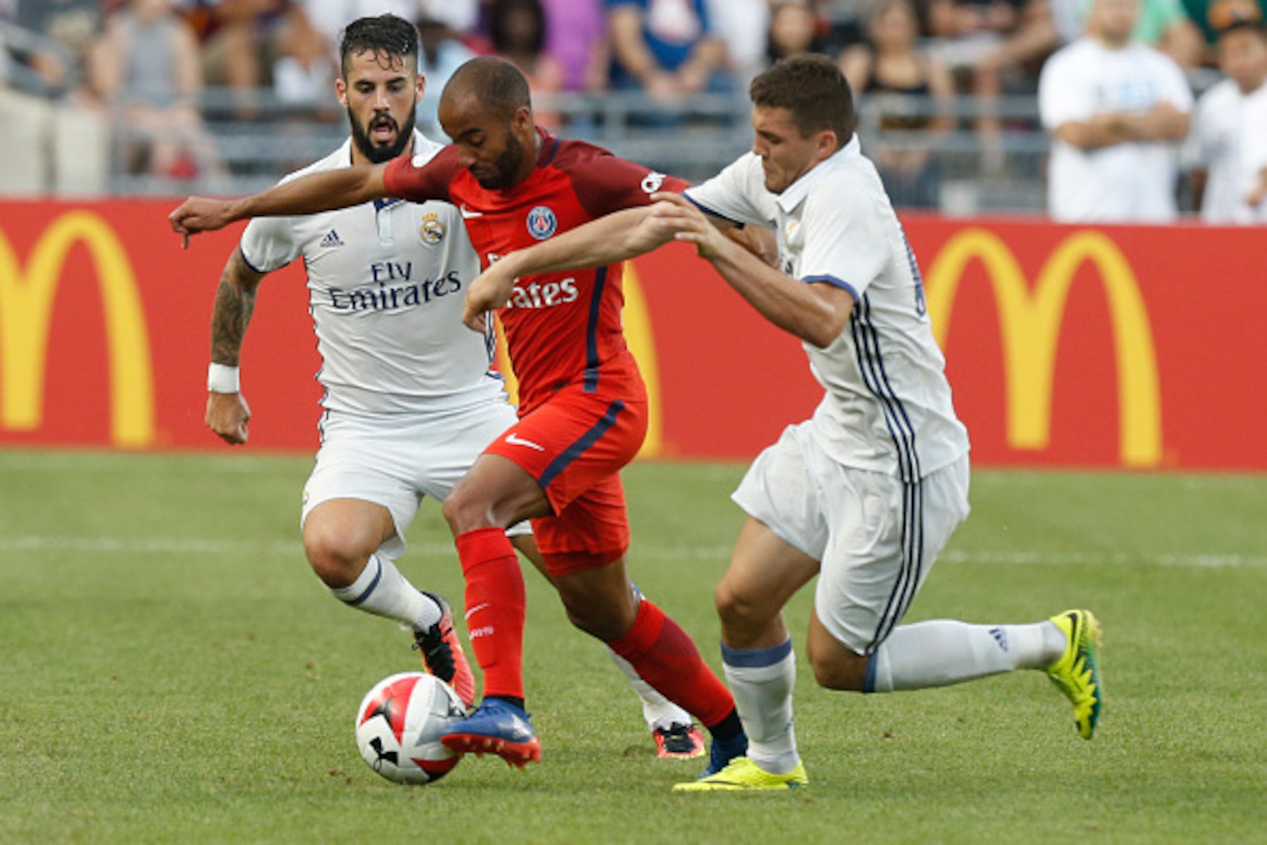 Paris Saint-Germain midfielder Lucas (C) carries the ball between Real Madrid forward Jese Rodriguez Ruiz (L) and midfielder midfielder Mateo Kovacic during an International Champions Cup soccer match in Columbus, Ohio on July 27, 2016. / AFP / Jay LaPret