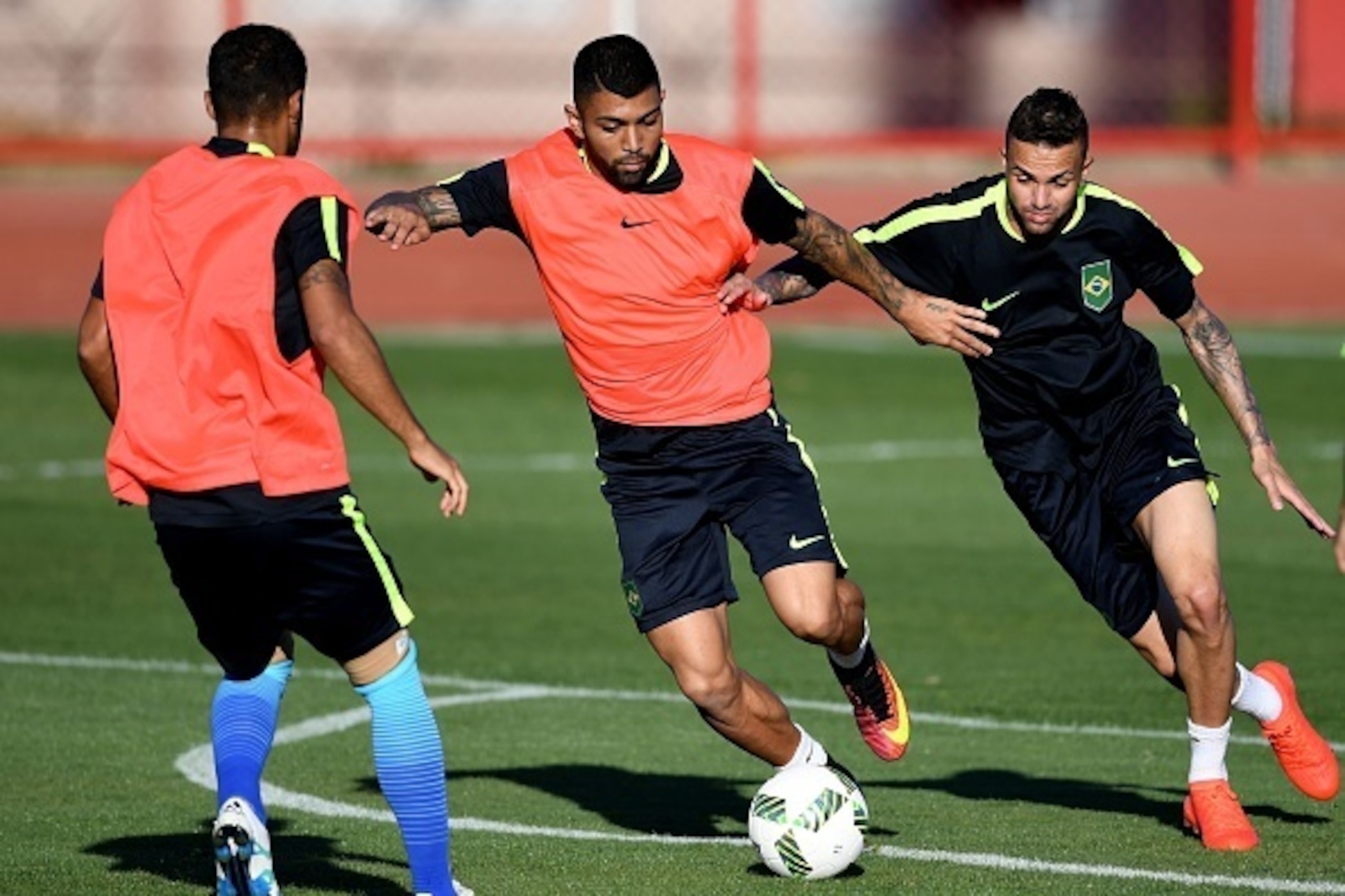 Brazilian footballers Gabriel Barbosa (C) and Luan vie for the ball during a training session at the Fire Department Training Center in Brasilia, on August 1, 2016.  
The Rio 2016 Olympic and Paralympic Games will be held in Brazil from August 5-21 and Se