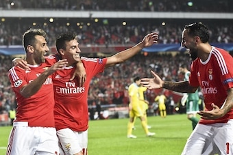 Benfica's Argentinian midfielder Nico Gaitan (C) celebrates a goal with teammate Brazilian forward Jonas Oliveira (L) and Greek forward Konstantinos Mitroglou (R) during the UEFA Champions League football match SL Benfica vs FC Astana at the Luz stadium i