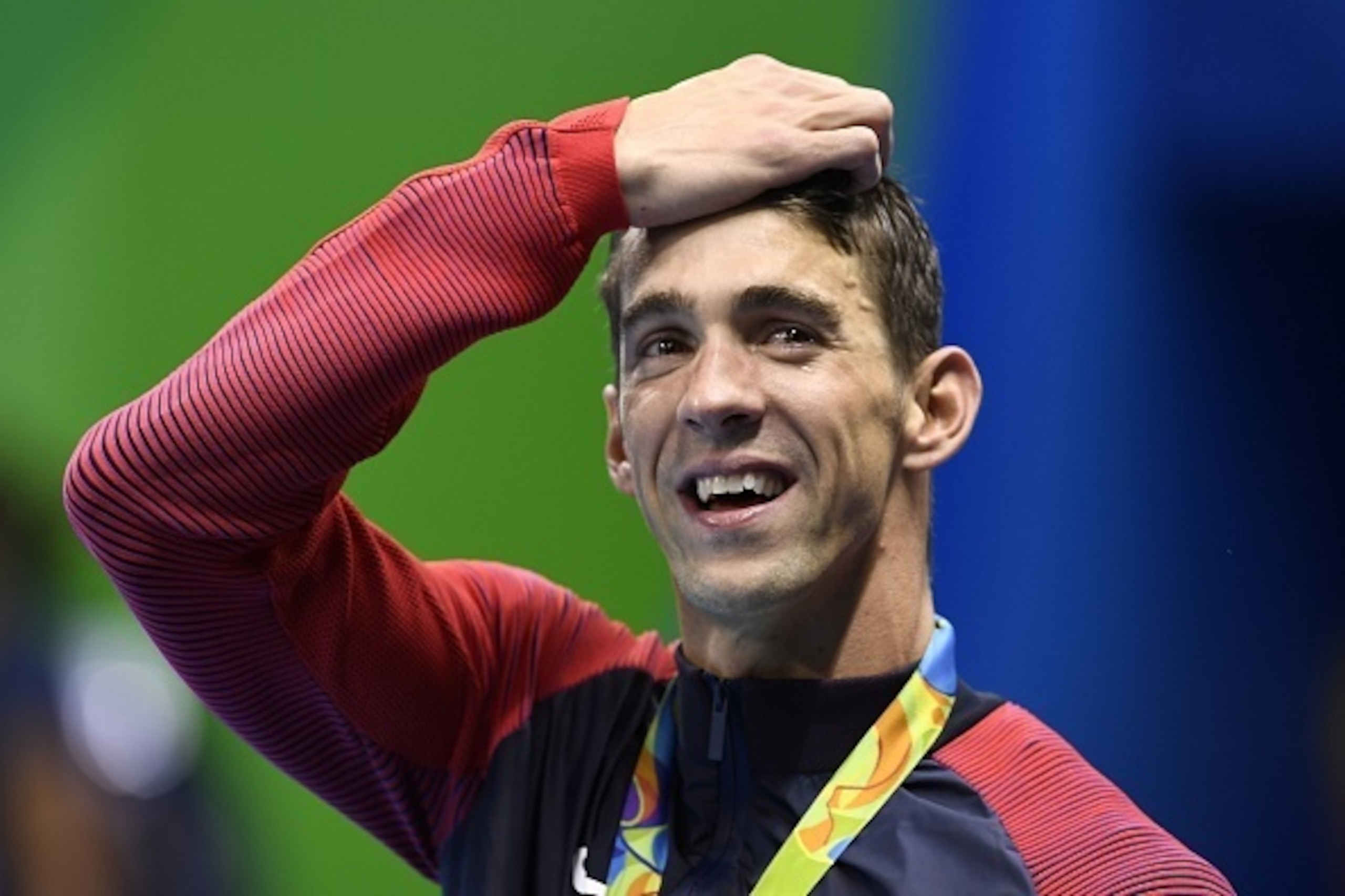 USA's Michael Phelps cries while posing with his gold medal on the podium of the Men's 4x100m Freestyle Relay Final during the swimming event at the Rio 2016 Olympic Games at the Olympic Aquatics Stadium in Rio de Janeiro on August 7, 2016.   / AFP / GABR