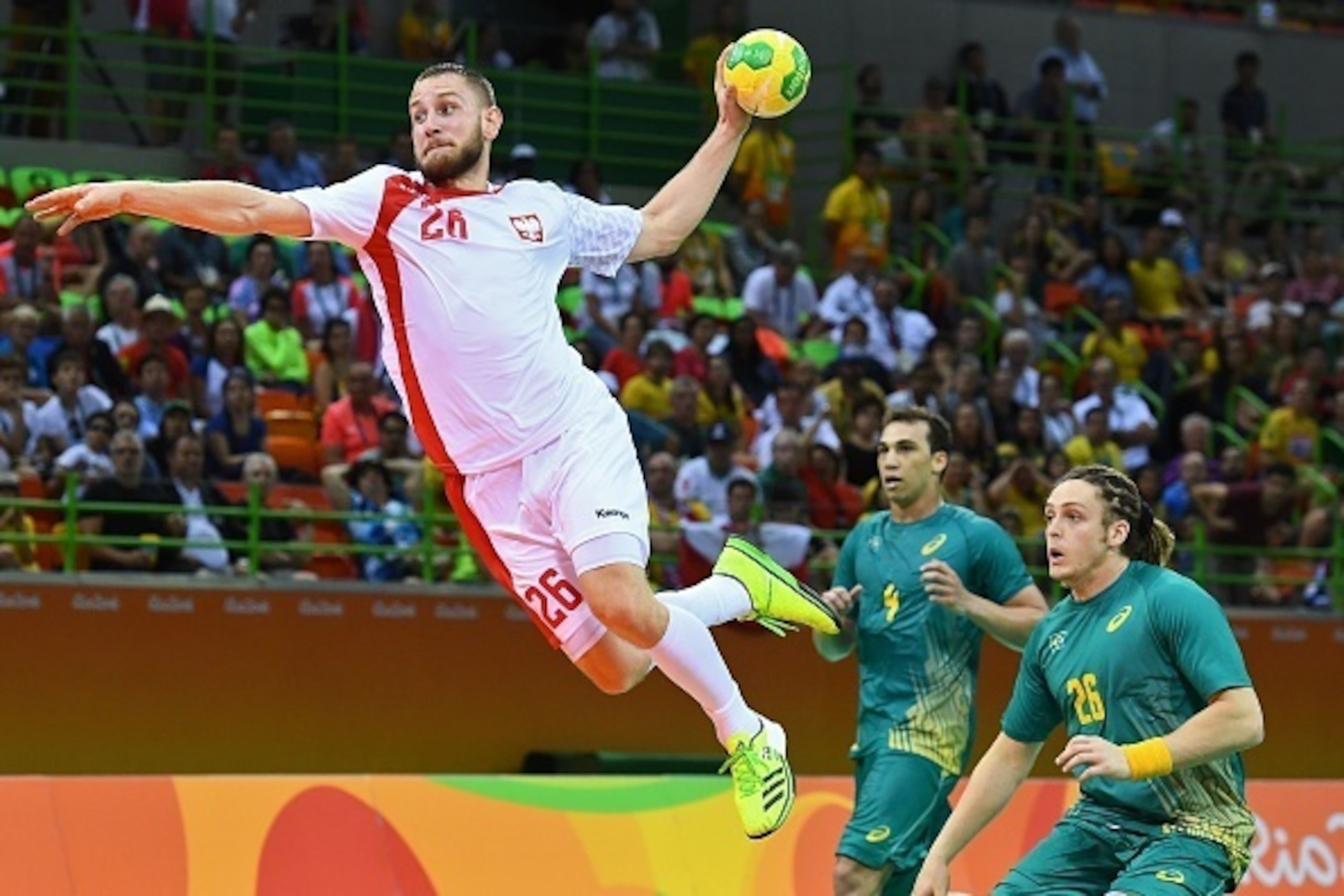 Poland's right wing Michal Daszek (L) jumps to shoot past Brazil's right back Oswaldo dos Santos Guimaraes (R) during the men's preliminaries Group B handball match Poland vs Brazil for the Rio 2016 Olympics Games at the Future Arena in Rio on August 7, 2