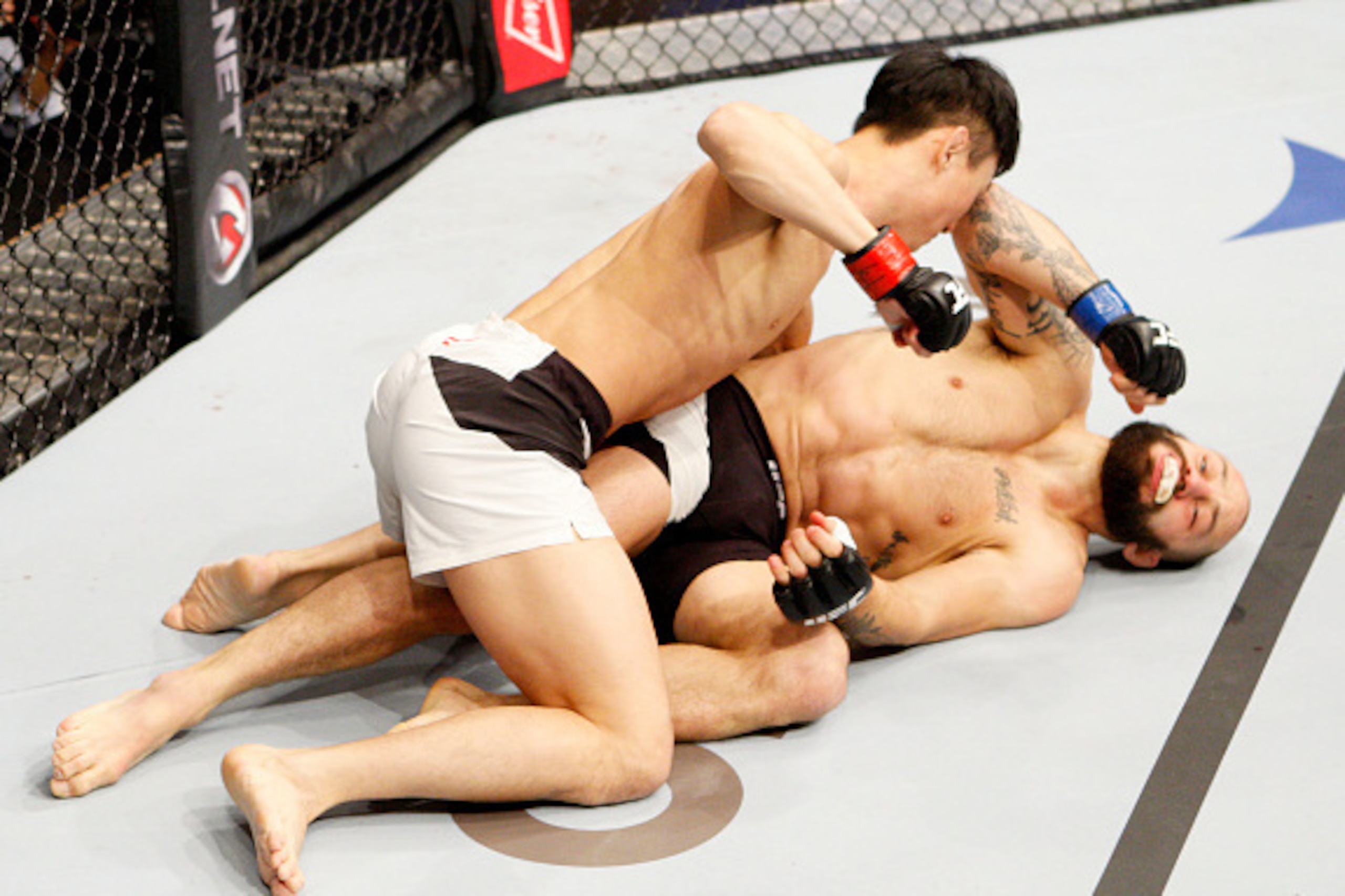 SEOUL, SOUTH KOREA - NOVEMBER 28: Doo Ho Choi of South Korea punches Sam Sicilia of the United States of America in their  featherweight bout during the UFC Fight Night at the Olympic Park Gymnastics Arena on November 28, 2015 in Seoul, South Korea. (Phot