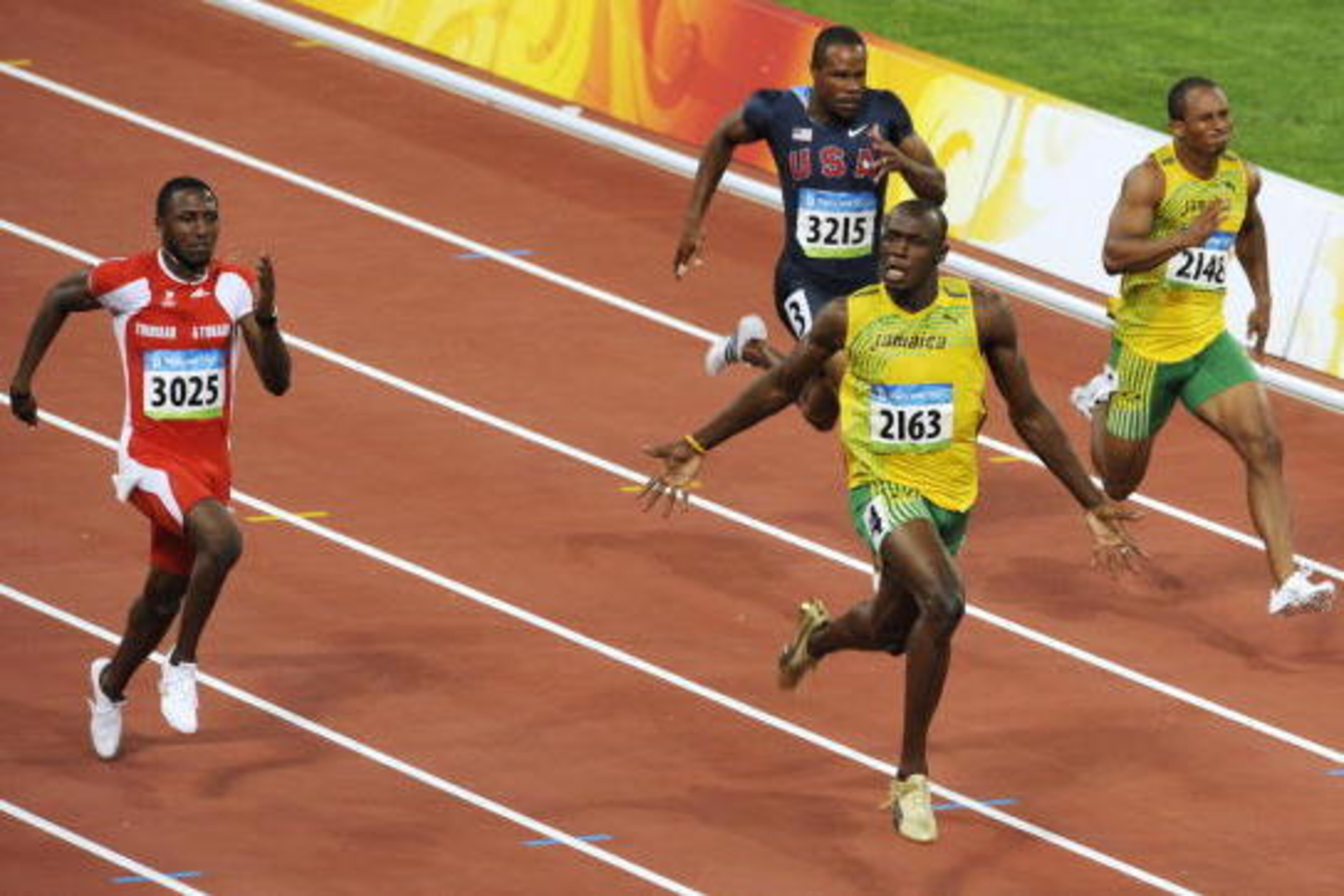 Jamaica's Usain Bolt (front) celebrates after winning the men's 100m final at the 'Bird's Nest' National Stadium during the 2008 Beijing Olympic Games on August 16, 2008. Bolt won the Olympic Games men's 100m gold medal in a new world record time of 9.69s