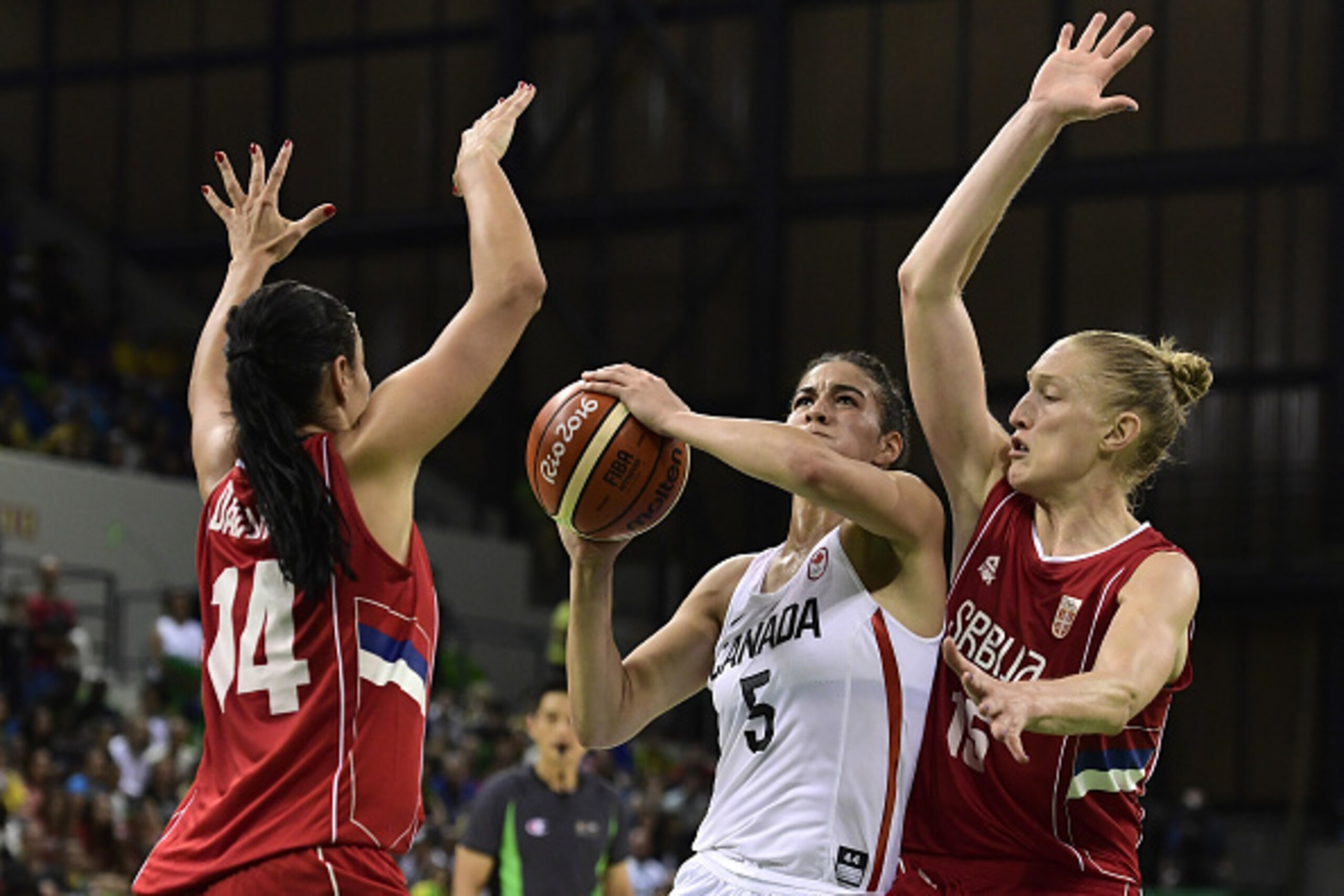Canada's guard Kia Nurse (C) is blocked by Serbia's shooting guard Ana Dabovic (L) and Serbia's power forward Danielle Page during a Women's round Group B basketball match between Canada and Serbia at the Youth Arena in Rio de Janeiro on August 8, 2016 du