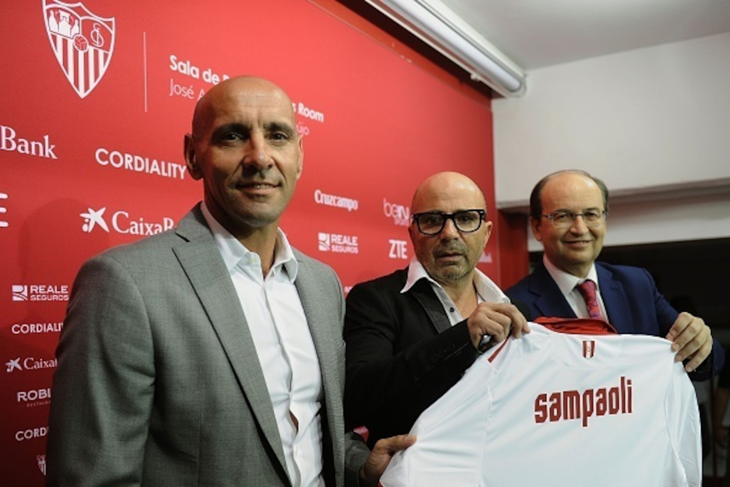 Sevilla's new Argentinian coach Jorge Sampaoli (C) holds a jersey with his name between Sevilla's President Jose Castro (R) and technical director Monchi during his official presentation at the Ramon Sanchez Pizjuan stadium in Sevilla on July 3, 2016. 

 