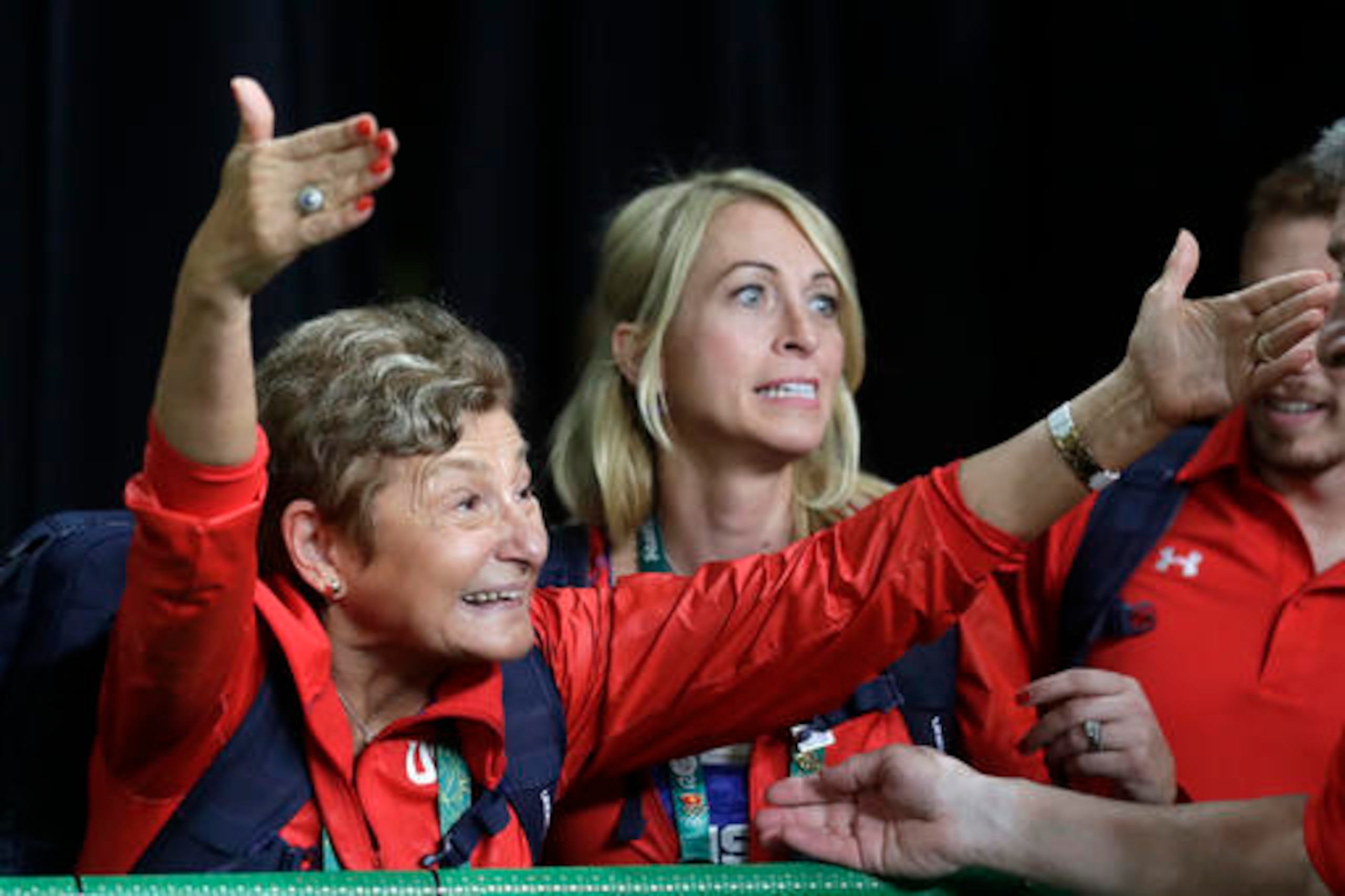 Martha Karolyi (left) celebrates team gold from the stands.