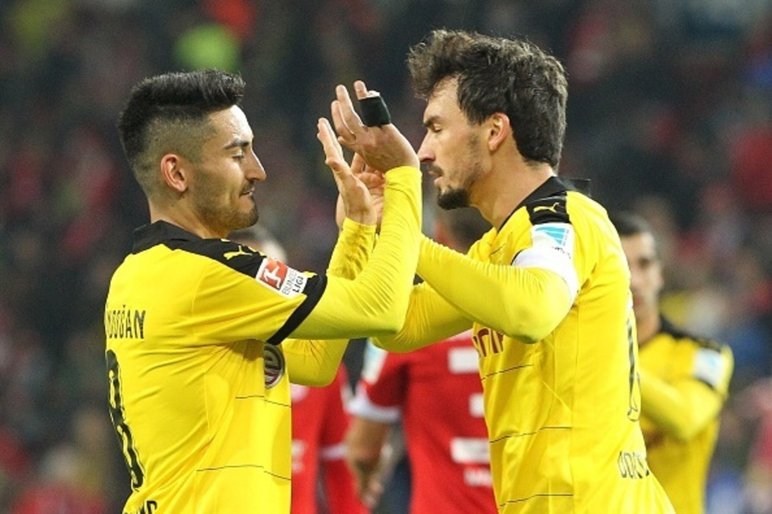Dortmund's midfielder Ilkay Guendogan (L) and Dortmund's defender Mats Hummels celebrate after the German first division Bundesliga football match FSV Mainz 05 vs Borussia Dortmund in Mainz, western Germany, on October 16, 2015. Dortmund won the match 0-2