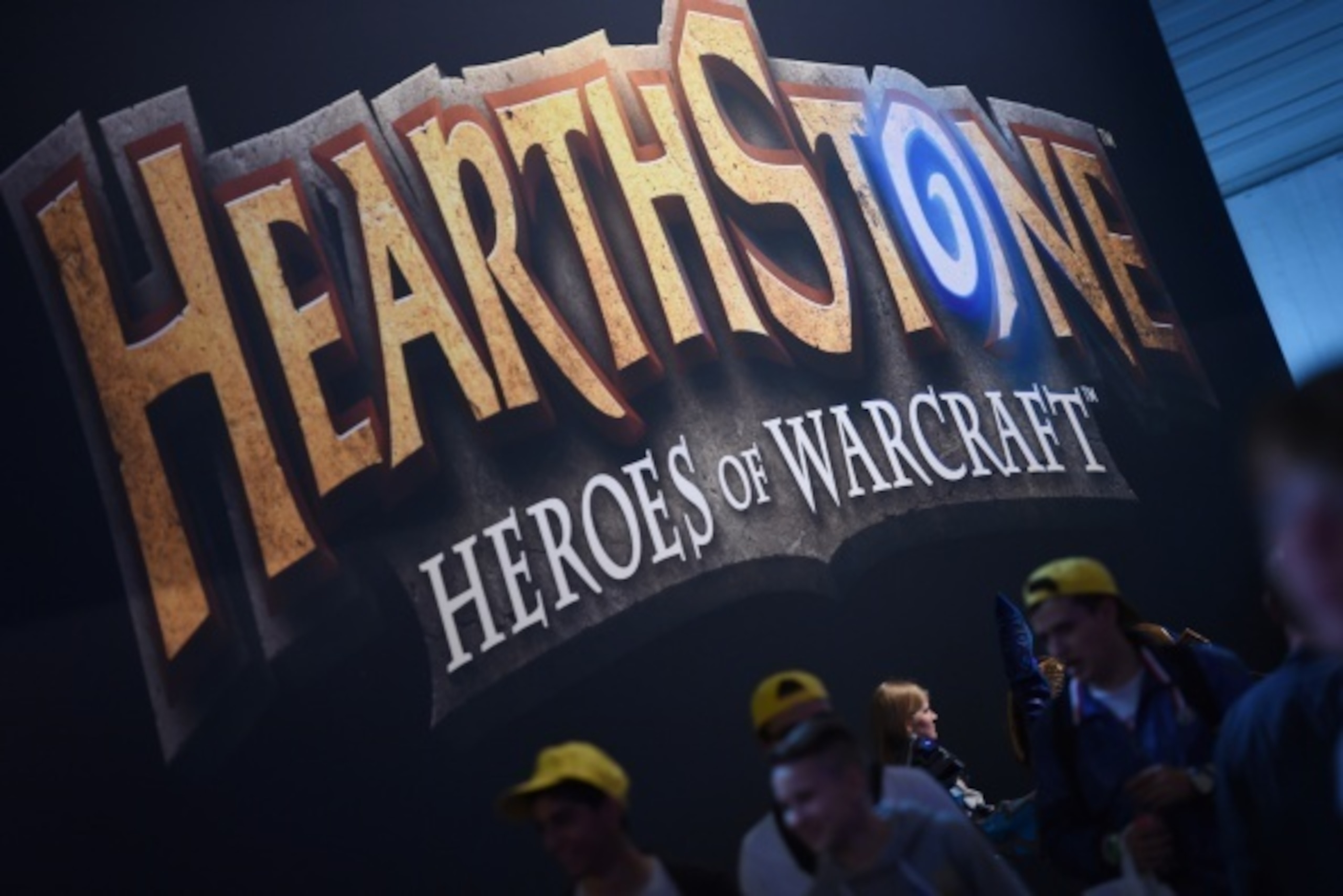 Visitors of the 'Gamescom' pass a display of the 'HEARTHSTONE' game on August 14, 2014 during the Gamescom fair in Cologne, western Germany. The trade fair for interactive games is running until August 17, 2014. PHOTO / PATRIK STOLLARZ        (Photo credi