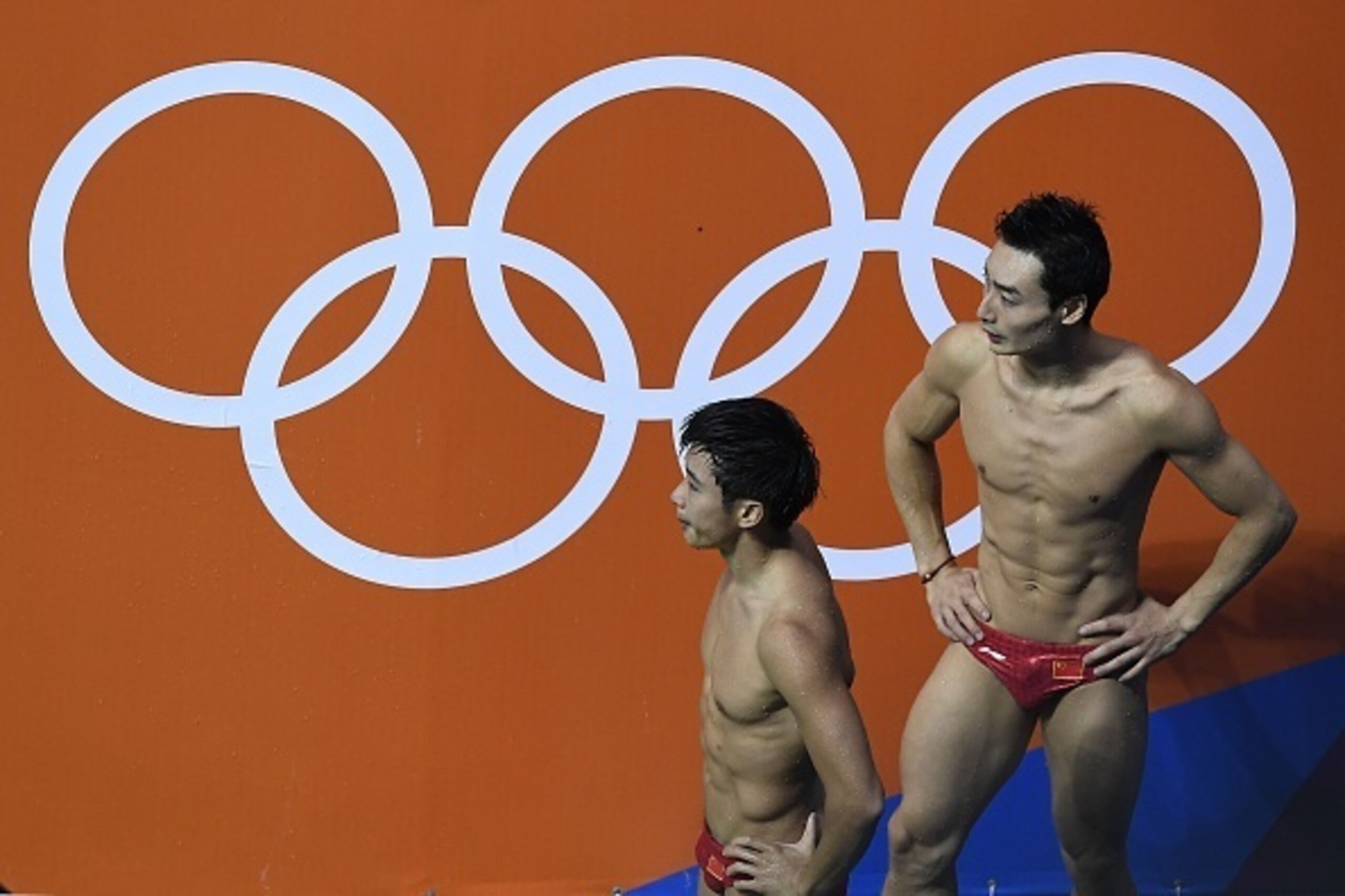 China's Cao Yuan and China's Qin Kai wait for the judges' decision during  the Men's Synchronised 3m Springboard Final during the diving event at the Rio 2016 Olympic Games at the Maria Lenk Aquatics Stadium in Rio de Janeiro on August 10, 2016.   / AFP /
